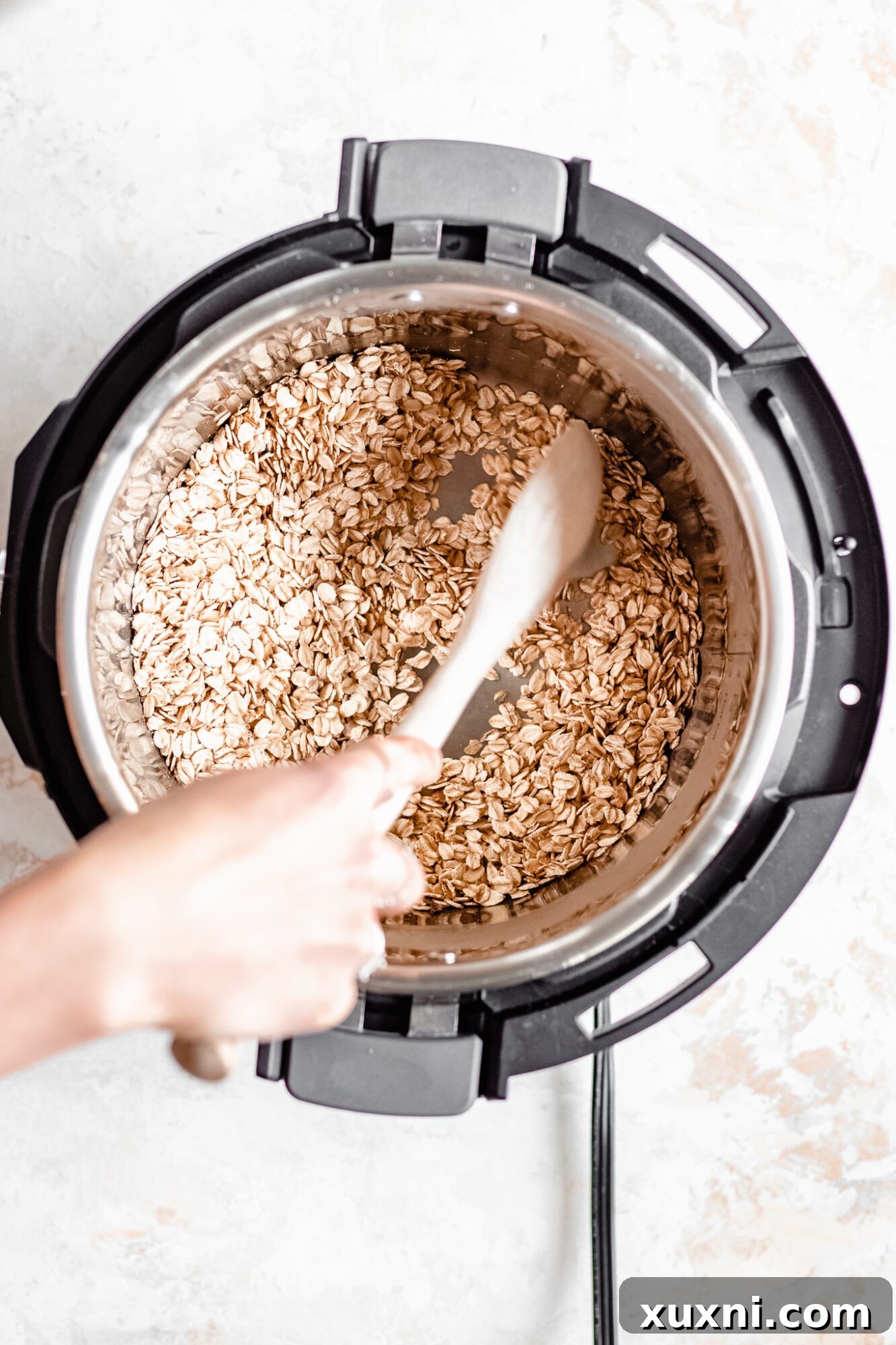 Instant Pot Protein Packed Vegan Zucchini Oatmeal 8 hand gently sautéing oats and spices in an Instant Pot