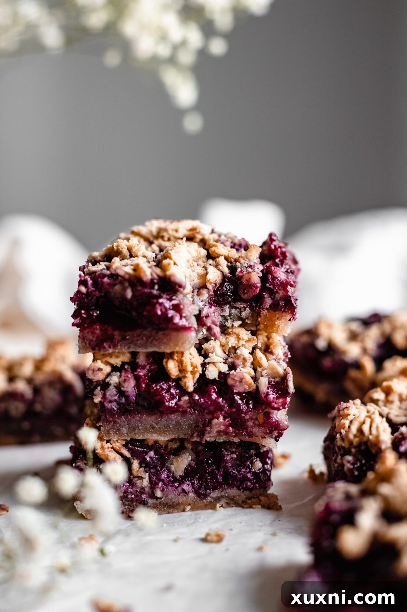 A stack of perfectly golden and delicious blueberry crumble bars, highlighting their appealing layers.