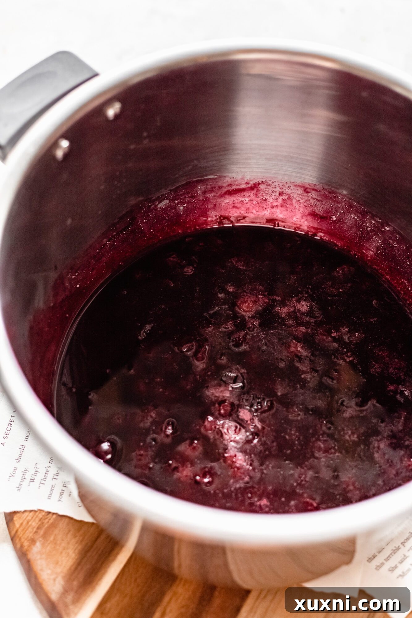 Close-up of vibrant blueberry pie filling bubbling gently in a pot, ready to be incorporated into the bars.
