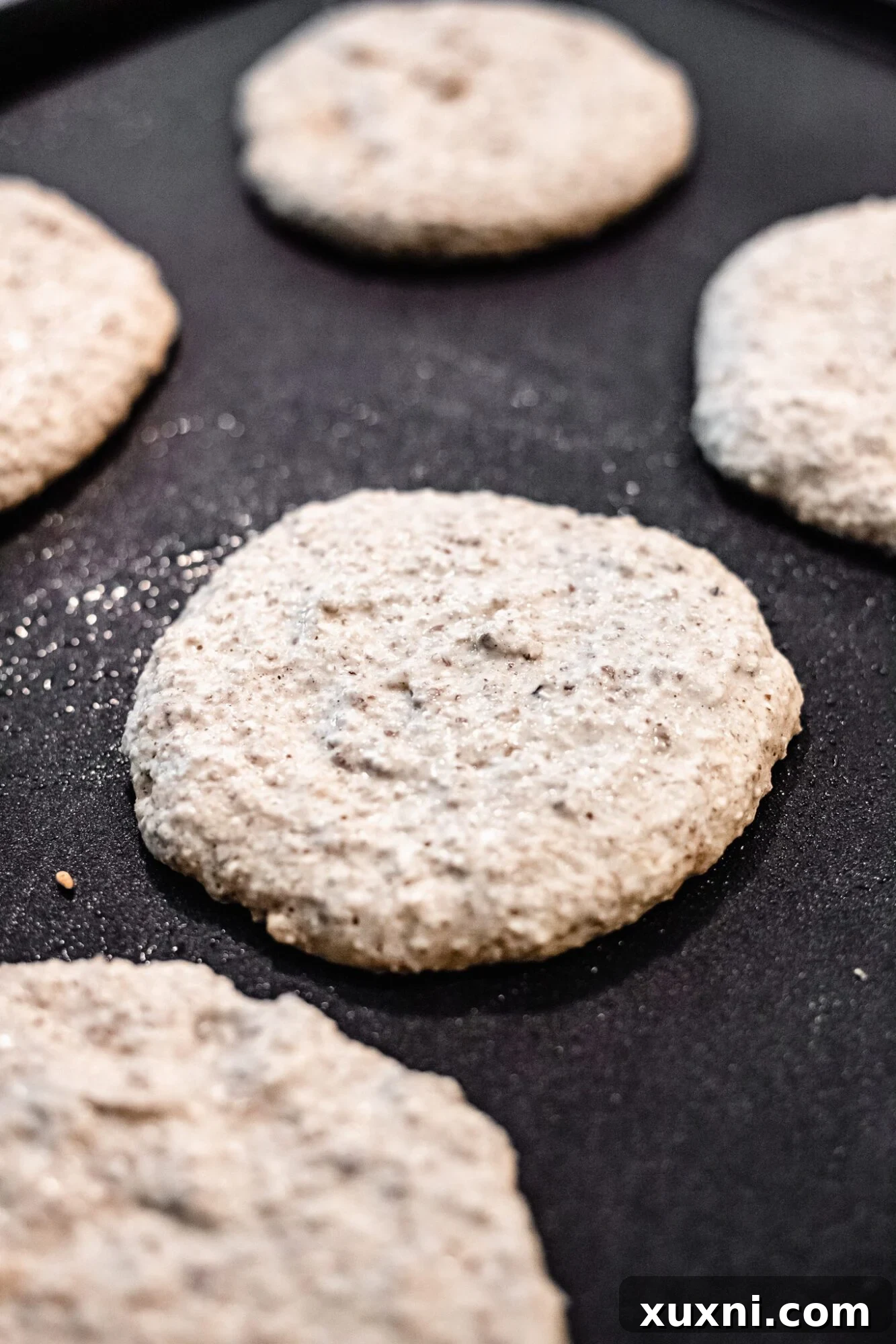 uncooked pancakes on griddle