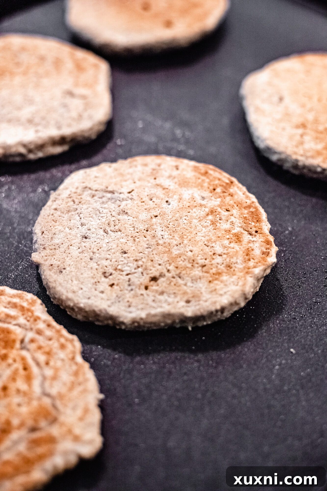 cooked oatmeal pancakes on griddle