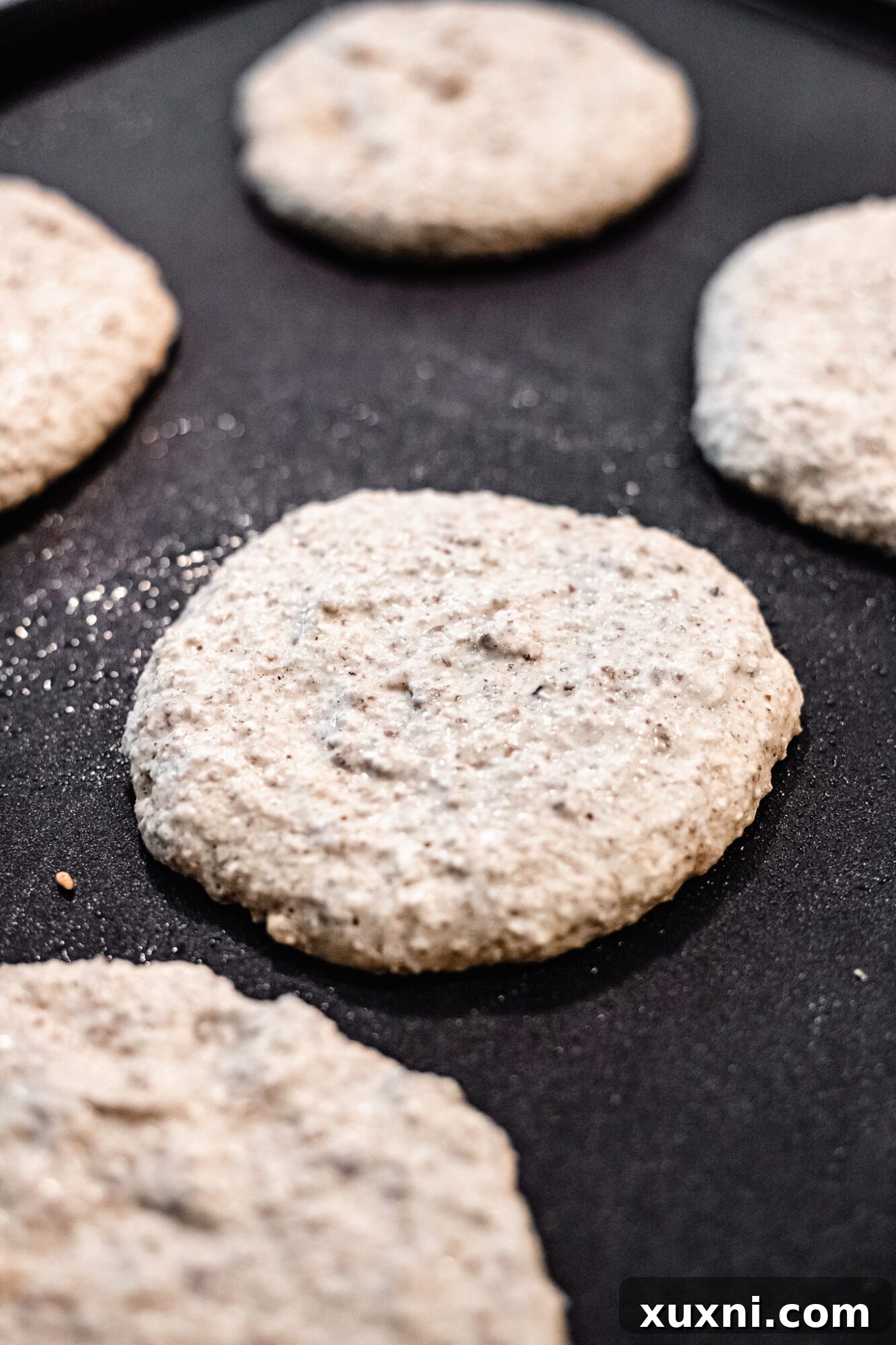 uncooked pancakes on griddle