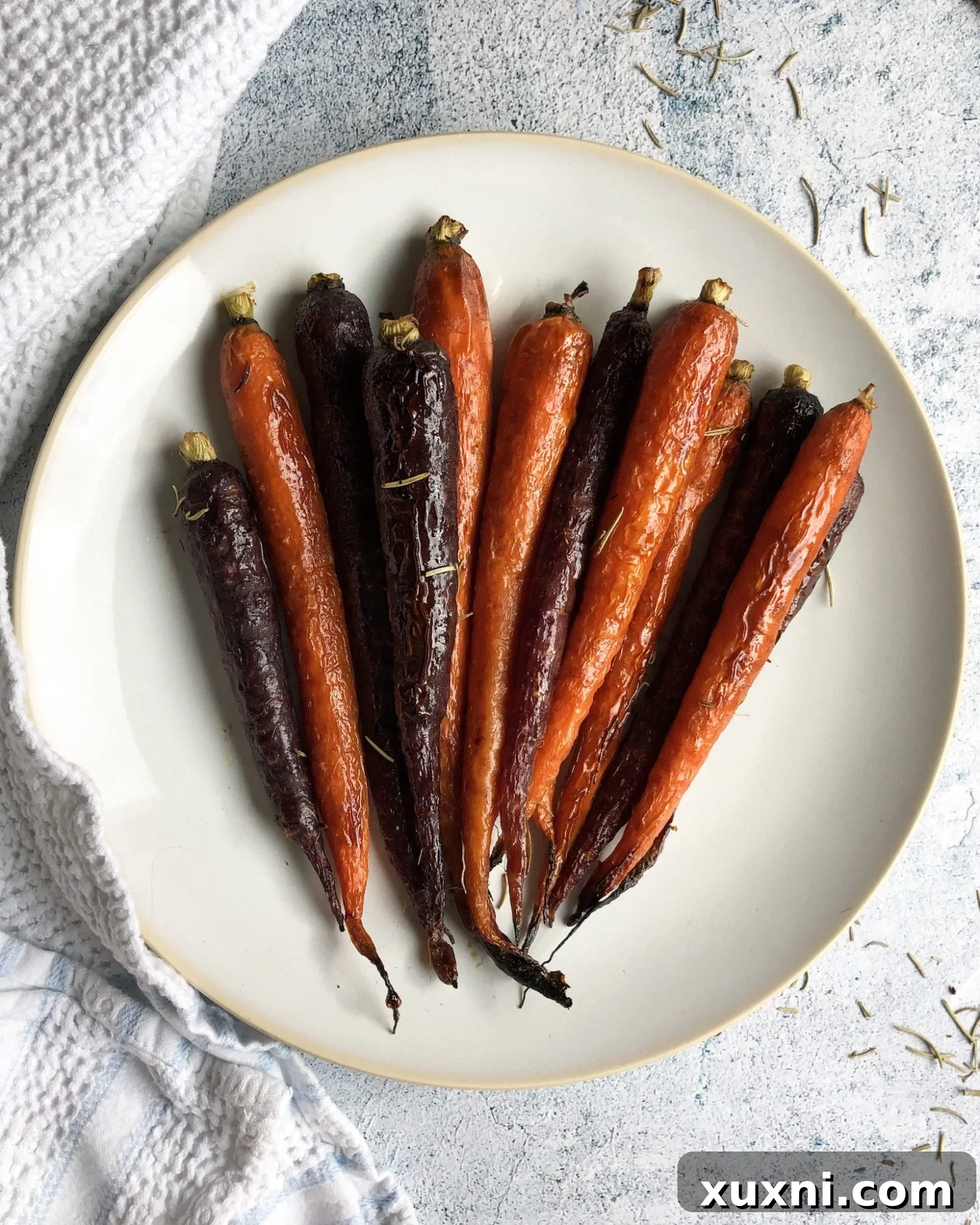 A vibrant platter of paleo vegan maple balsamic glazed carrots, garnished with fresh herbs and a sprinkle of vegan cheese, creating an inviting visual for a healthy and delicious meal.