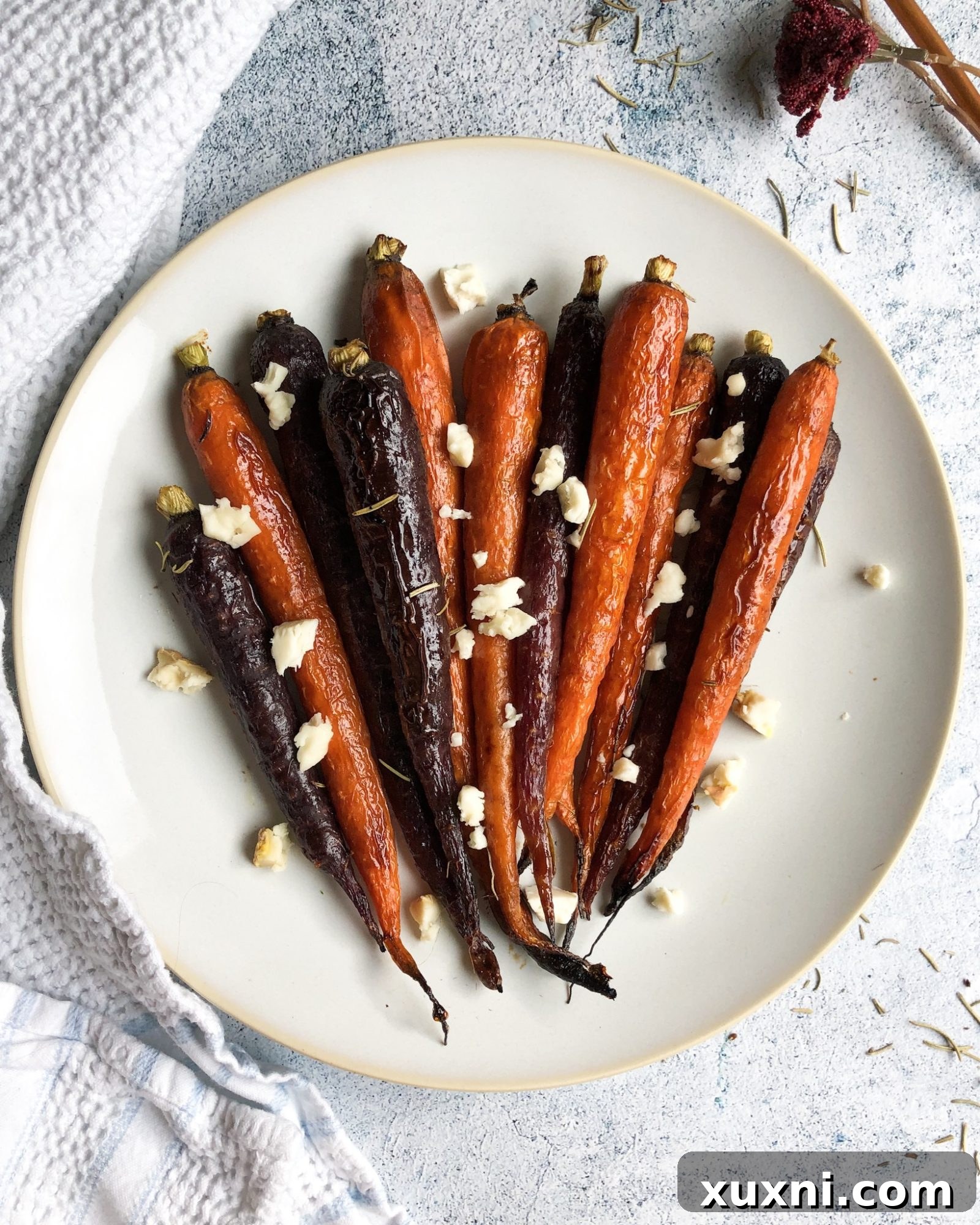 A festive holiday spread featuring paleo vegan maple balsamic glazed carrots as a centerpiece side dish, surrounded by other delicious options.