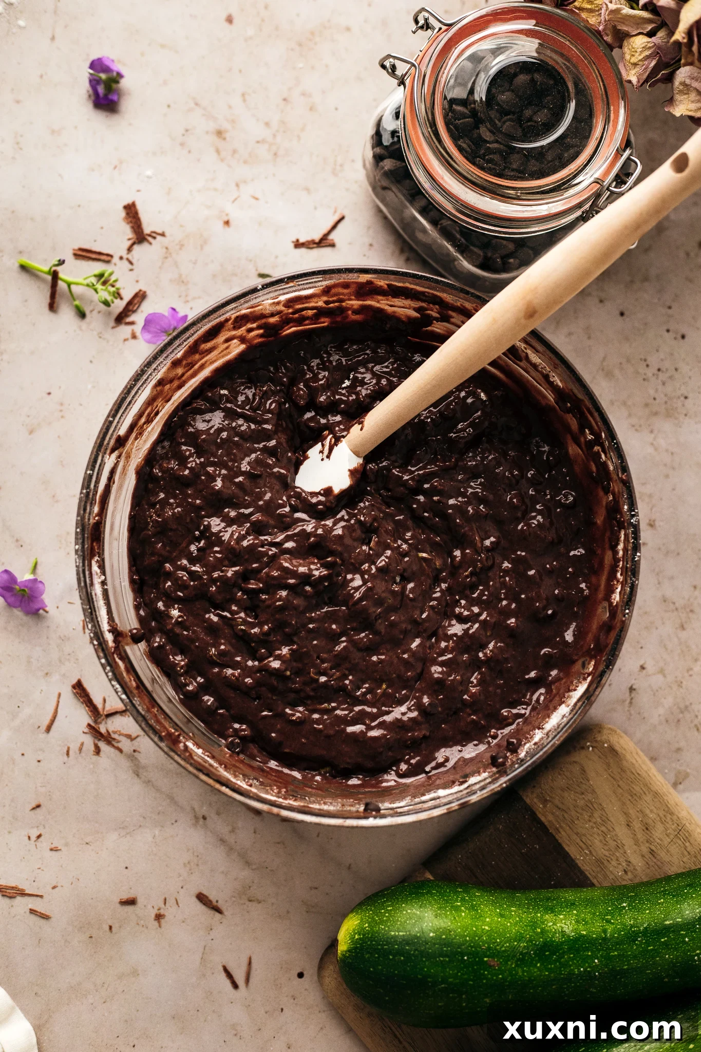 Preparing vegan chocolate zucchini bread batter, a rich mixture ready for baking with hidden zucchini.