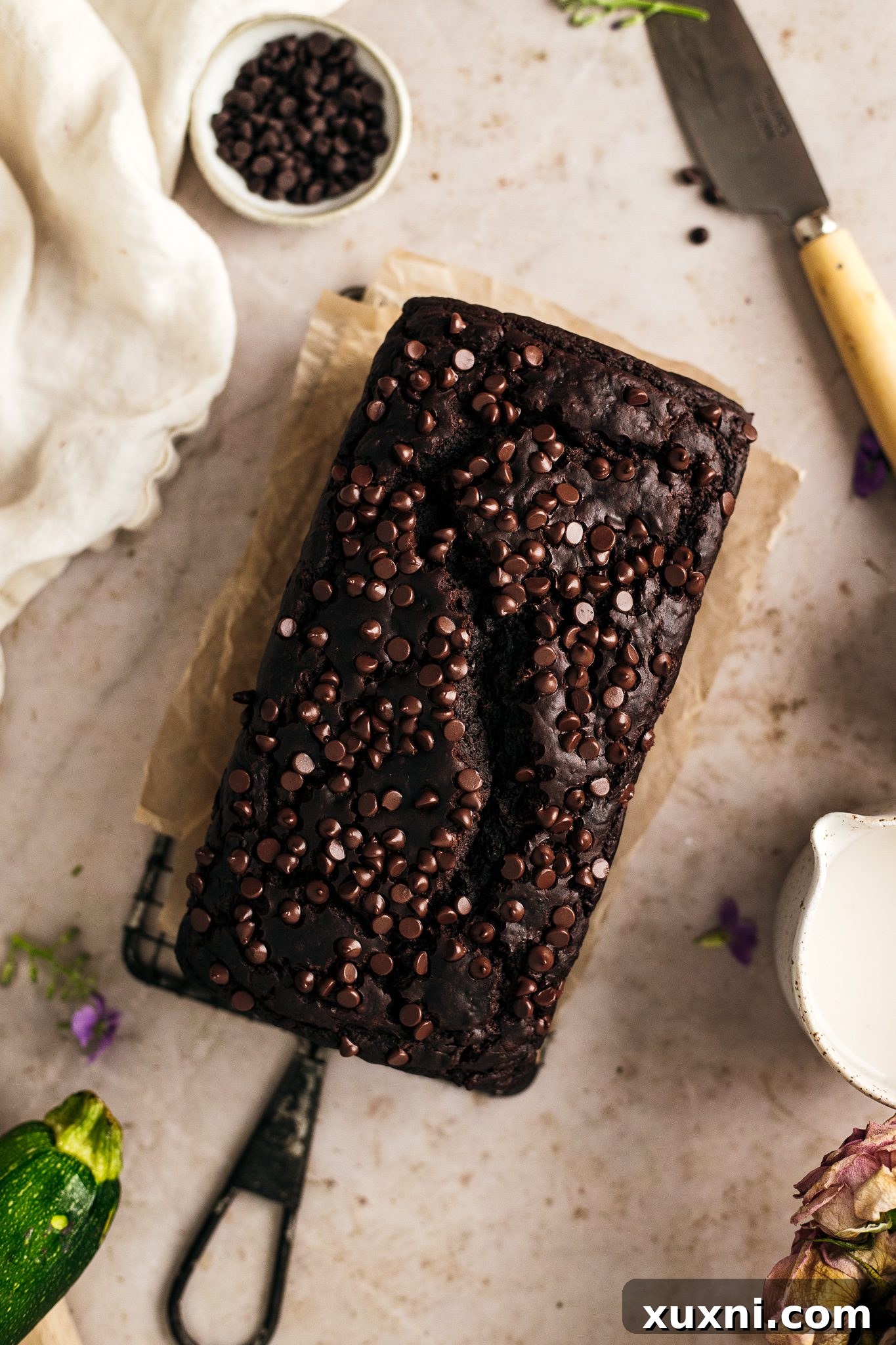 Freshly baked vegan chocolate zucchini bread cooling on a wire rack, its crust perfectly set and inviting.