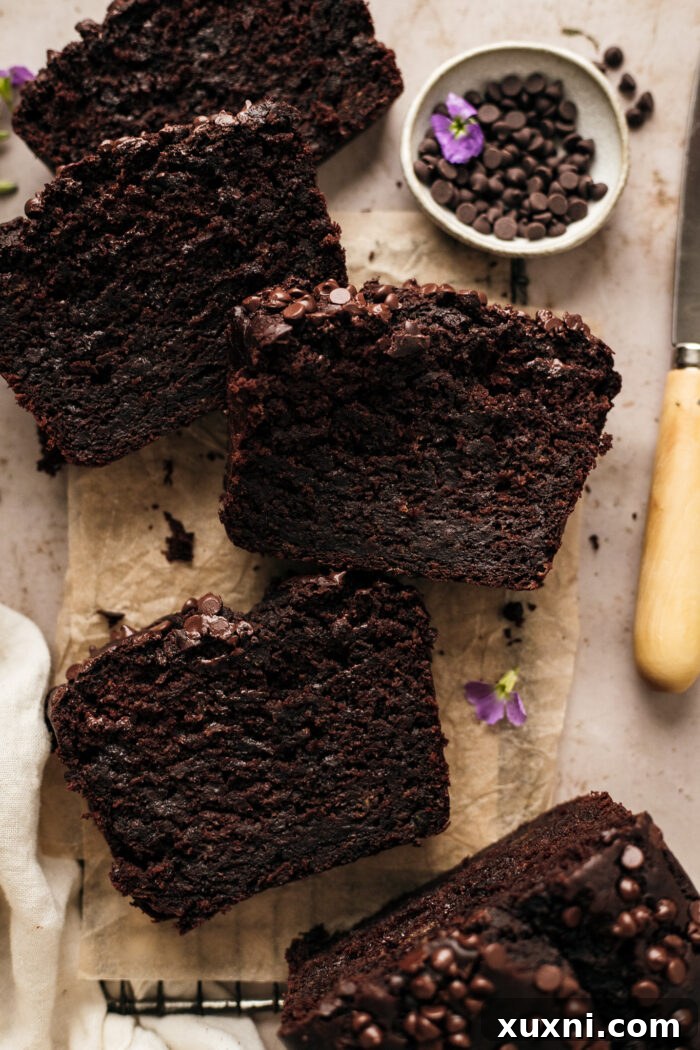 A top-down view of a single slice of vegan zucchini bread, showcasing its moist interior and chocolate chips, ready to be enjoyed.