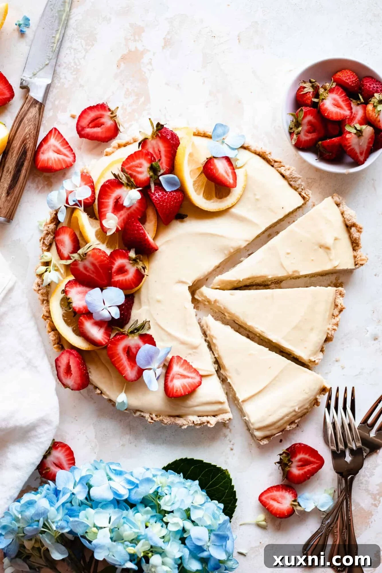 Sliced Easy Gluten-Free Vegan Lemon Tart topped with fresh strawberries, showcasing its creamy texture and vibrant color.
