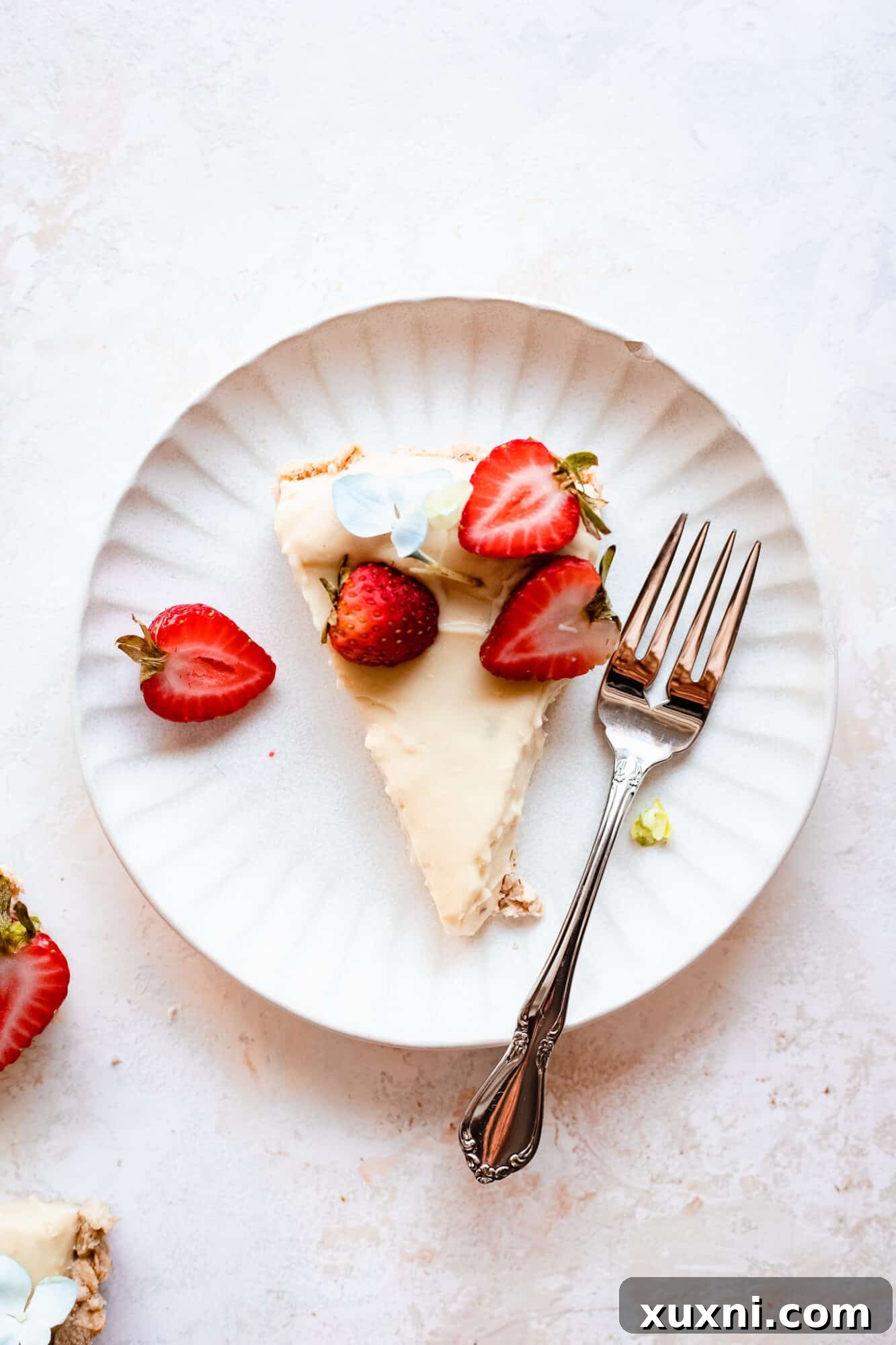A single, perfectly cut slice of vegan lemon tart, showing its distinct layers and appealing texture.