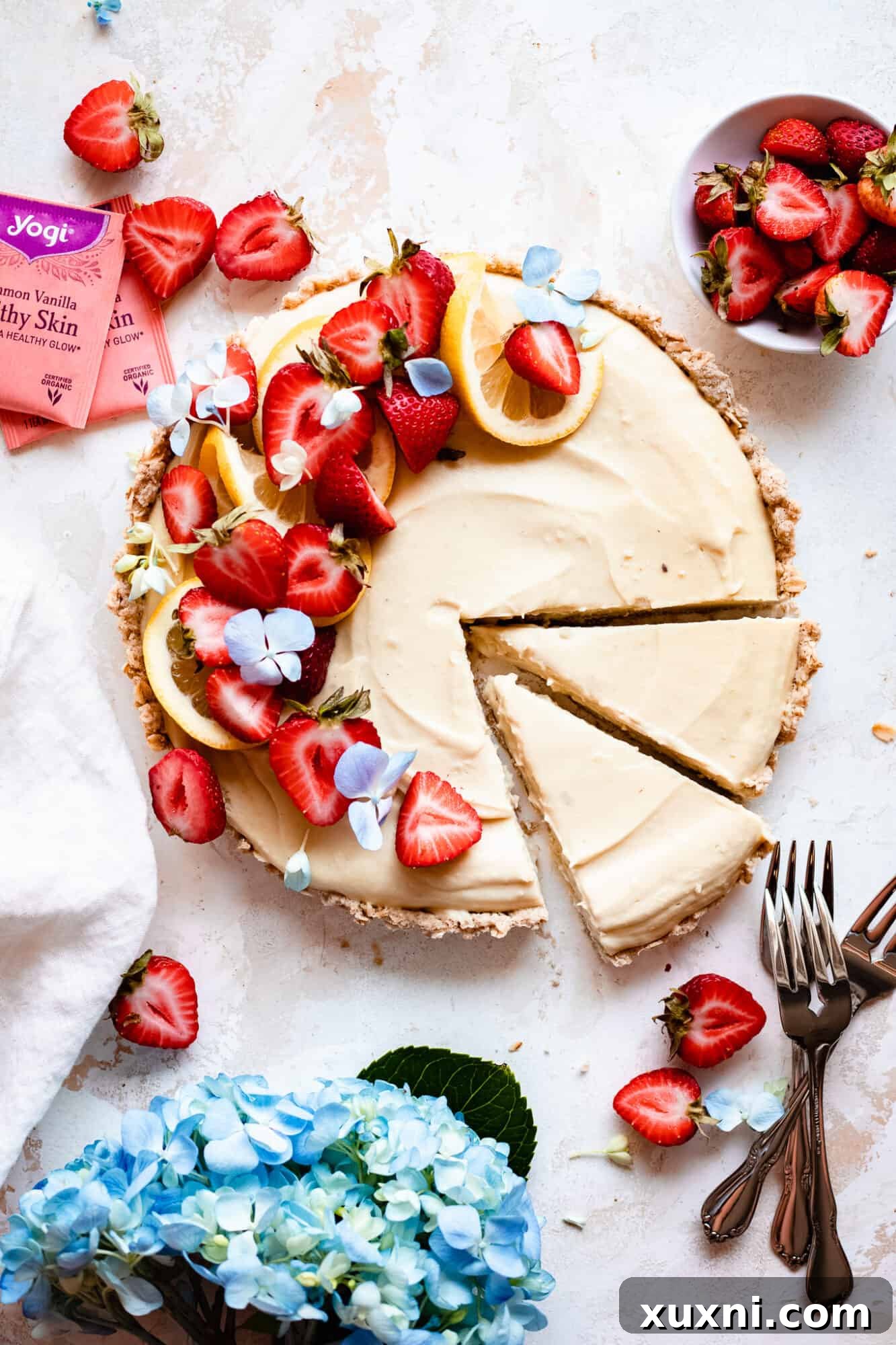 A slice of vegan lemon tart next to two Yogi Cinnamon Vanilla Healthy Skin Tea bags, illustrating the unique ingredient.