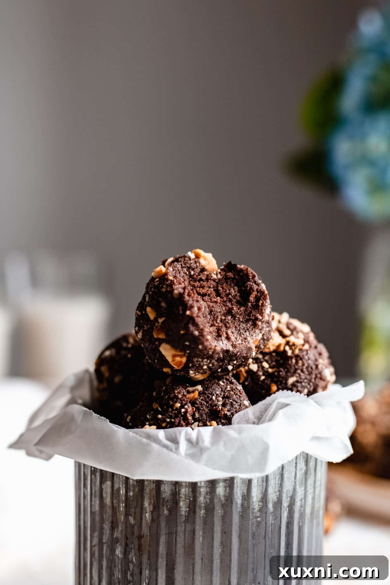 A close-up of a chocolate hazelnut energy bite with a small bite taken out, revealing its dense, rich interior.