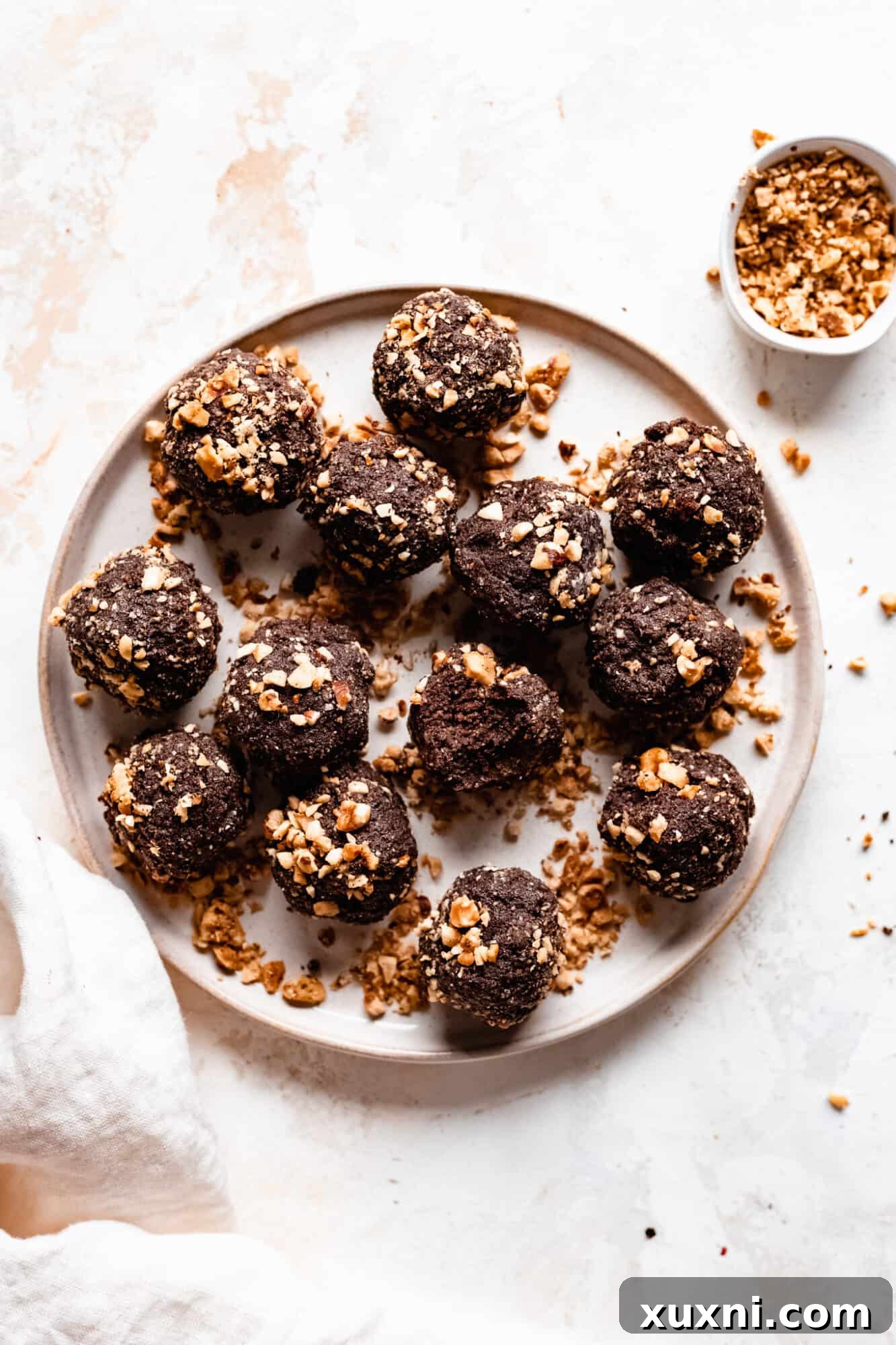 A plate featuring several perfectly formed chocolate hazelnut energy balls, a delicious and healthy snack.