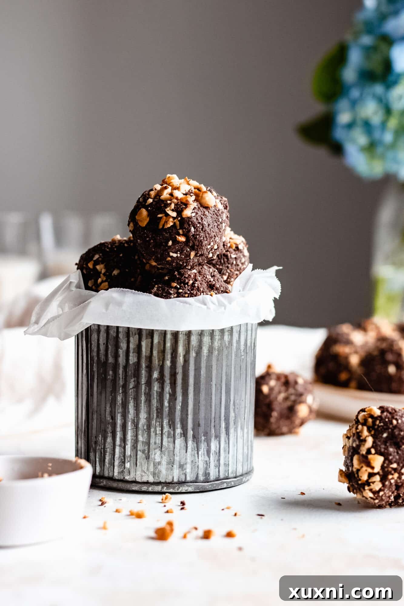 Several perfectly rounded chocolate hazelnut energy bites stacked neatly, showcasing their appealing texture.