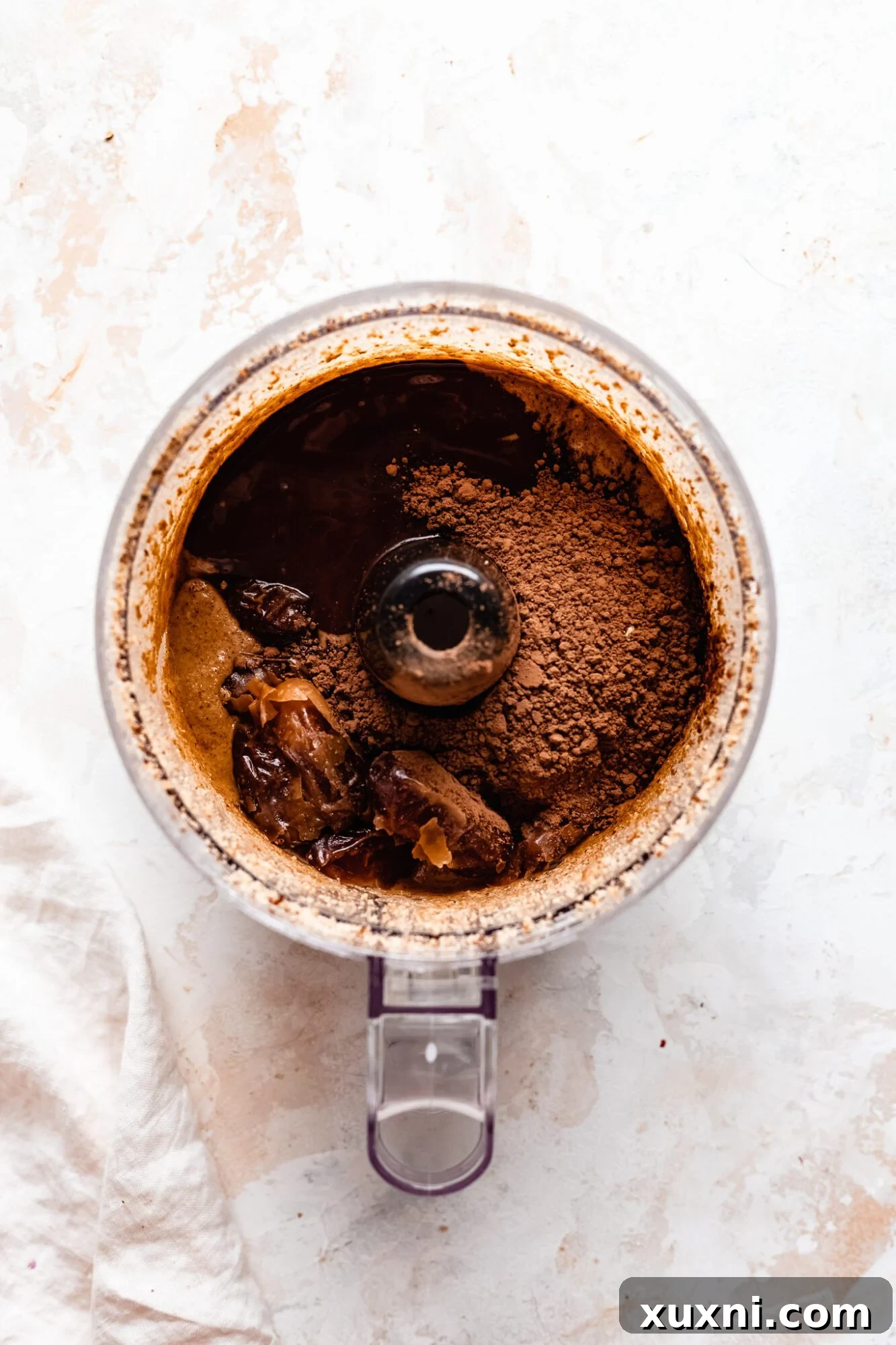 Hands rolling the energy bite dough into perfect round balls, ready for coating.