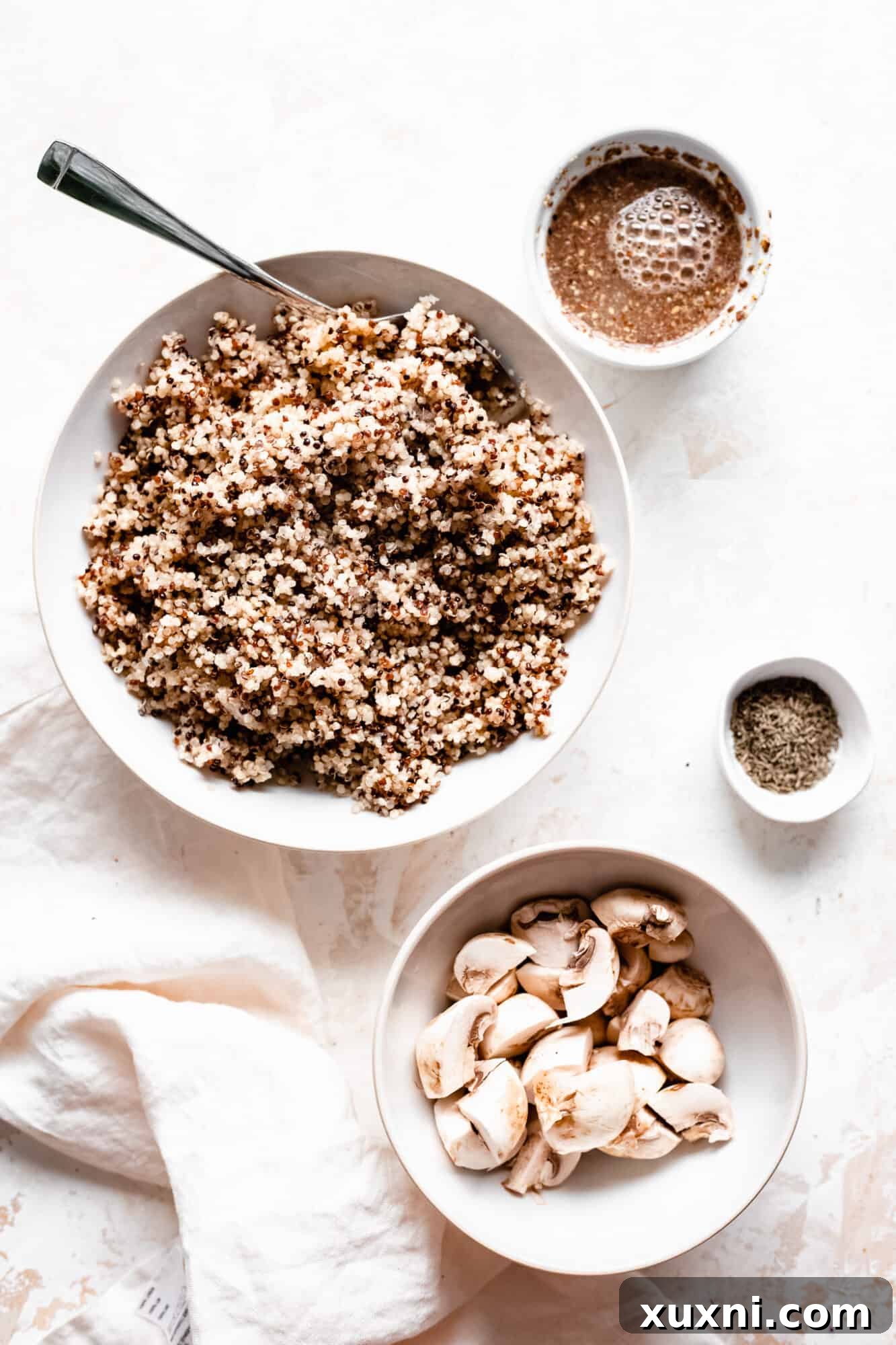Essential ingredients for vegan quinoa burgers laid out on a kitchen surface, highlighting simplicity.