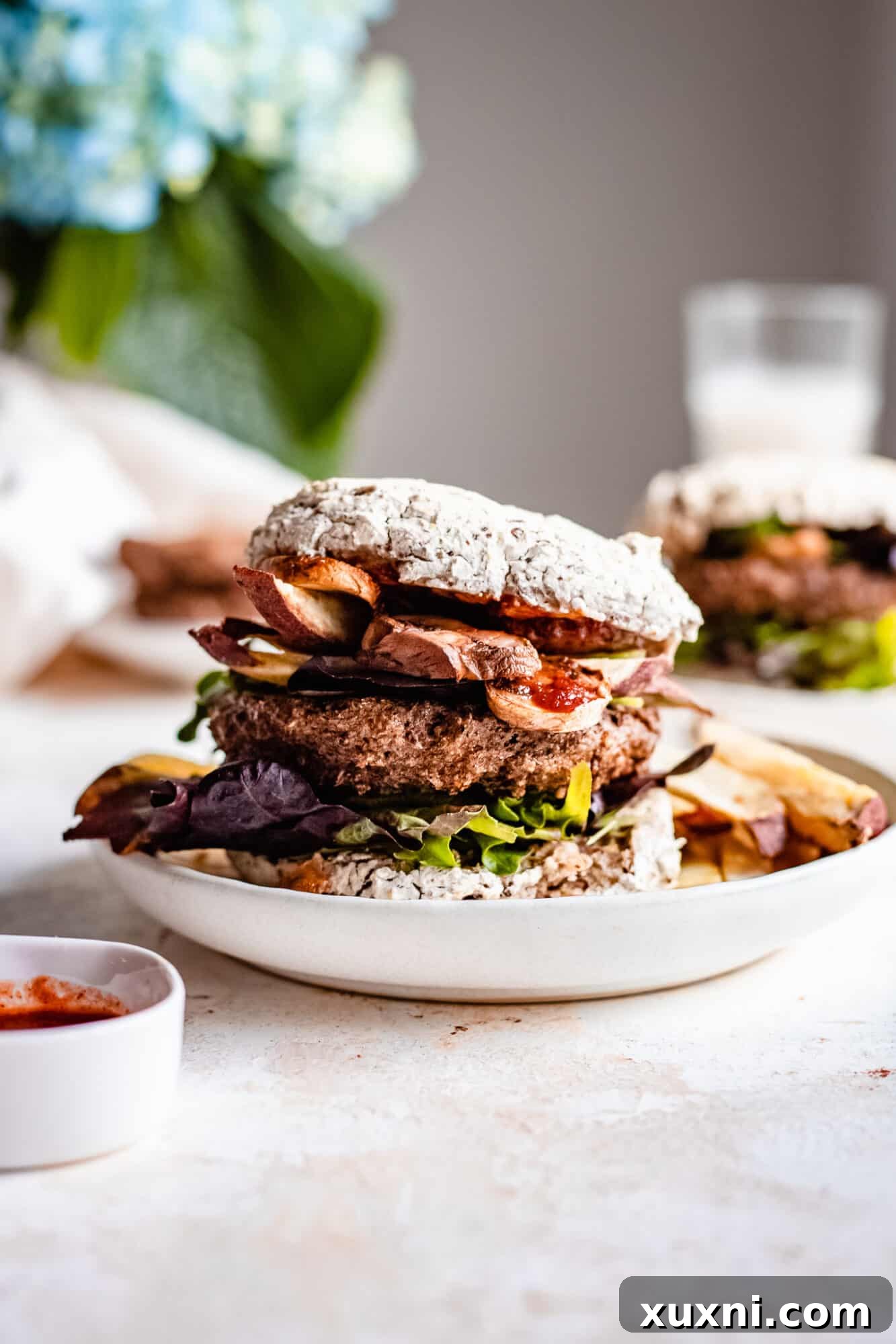 A delicious vegan veggie burger served elegantly on a white plate, ready to be enjoyed.