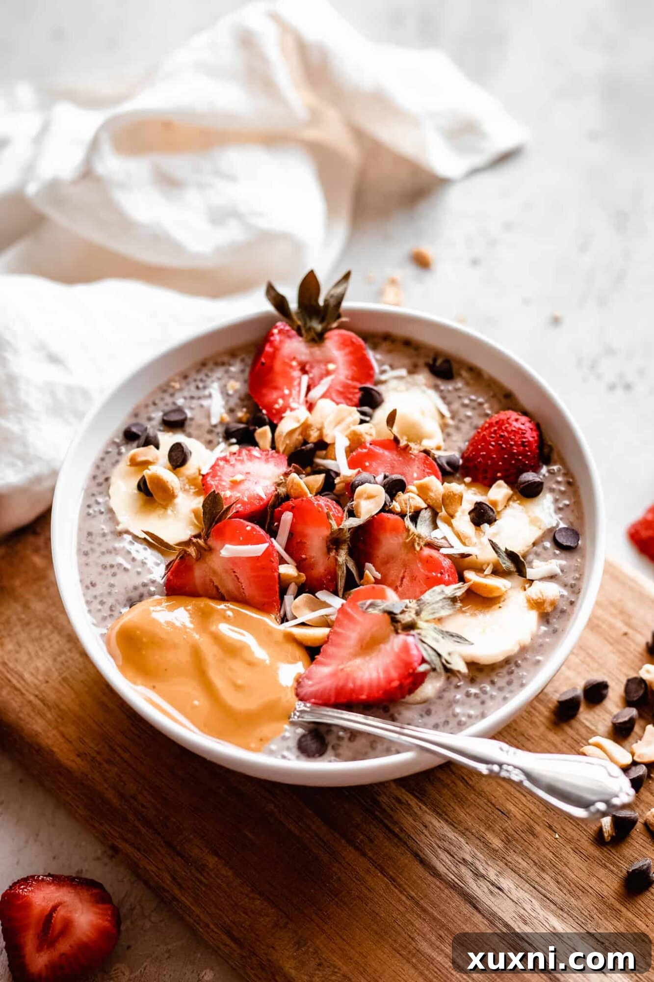 A beautifully presented bowl of banana chia pudding on a rustic wooden board