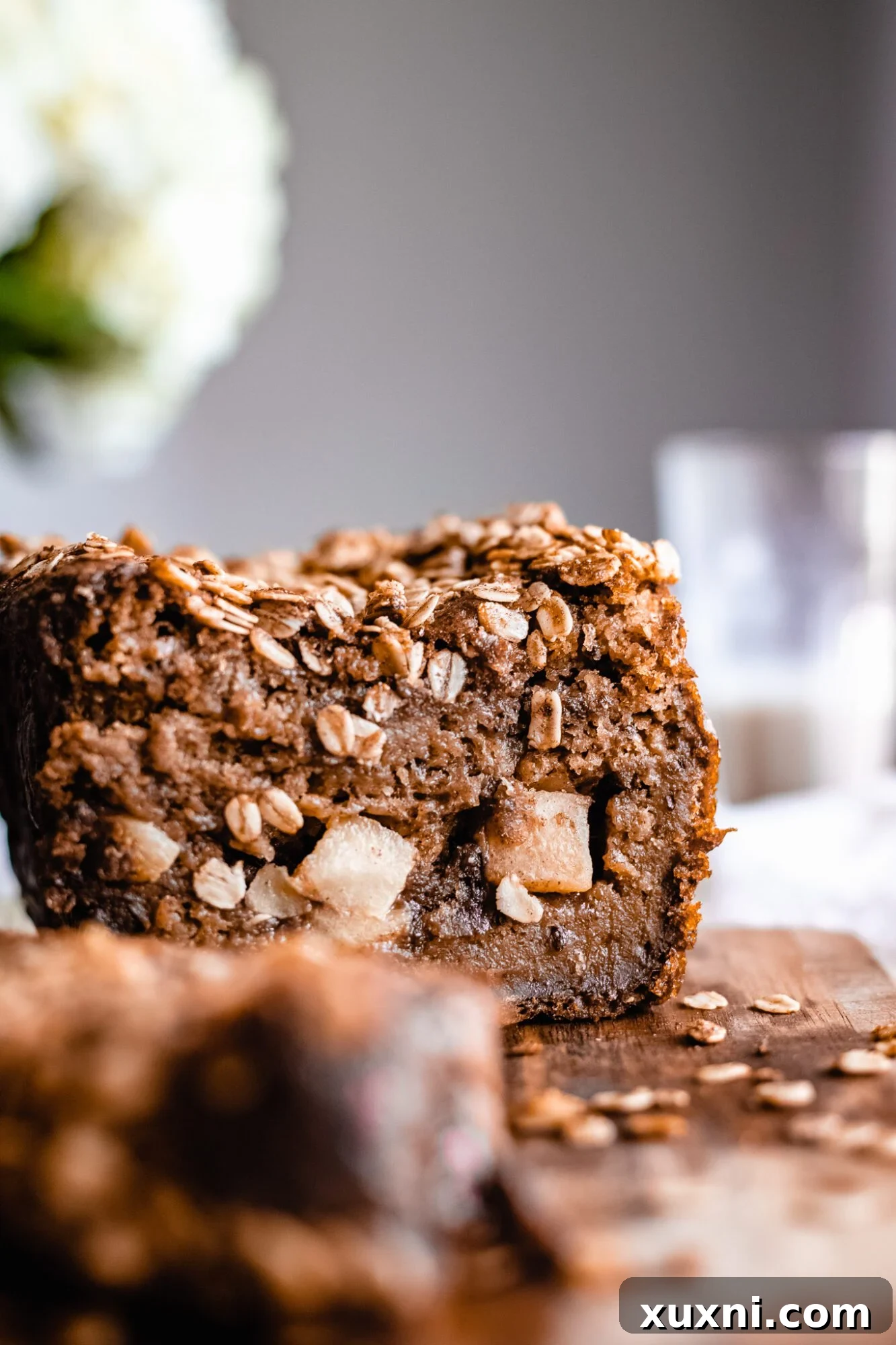 Close-up shot of baked vegan apple cinnamon bread, showing the rich cinnamon streusel and golden-brown oat topping.