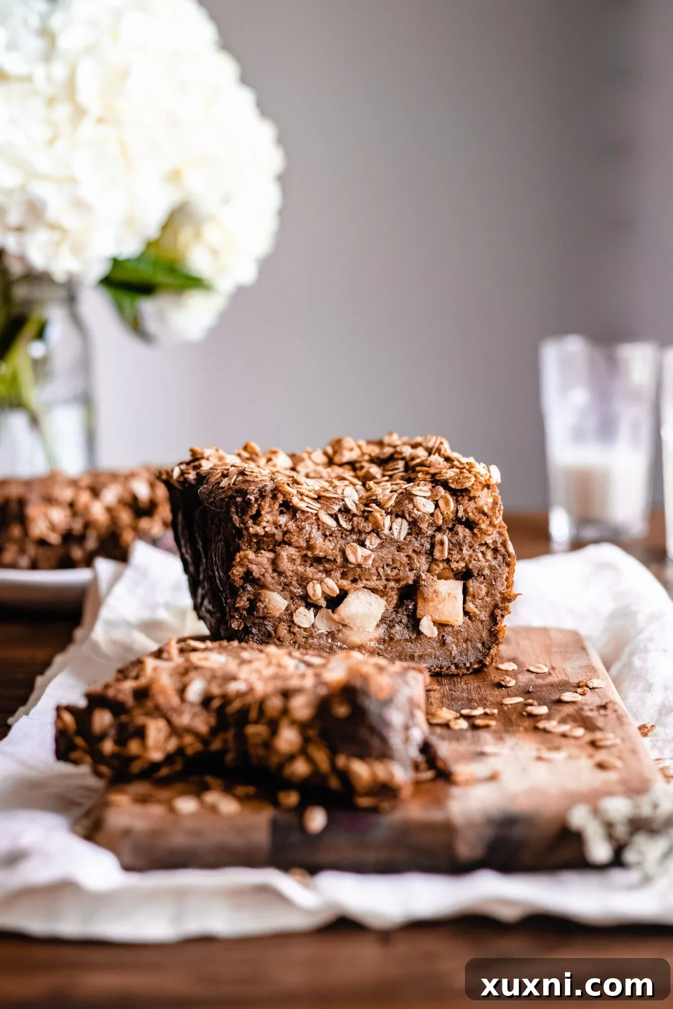 Stacked slices of healthy vegan apple cinnamon bread on a wooden board, showcasing the beautiful golden crust and soft interior.