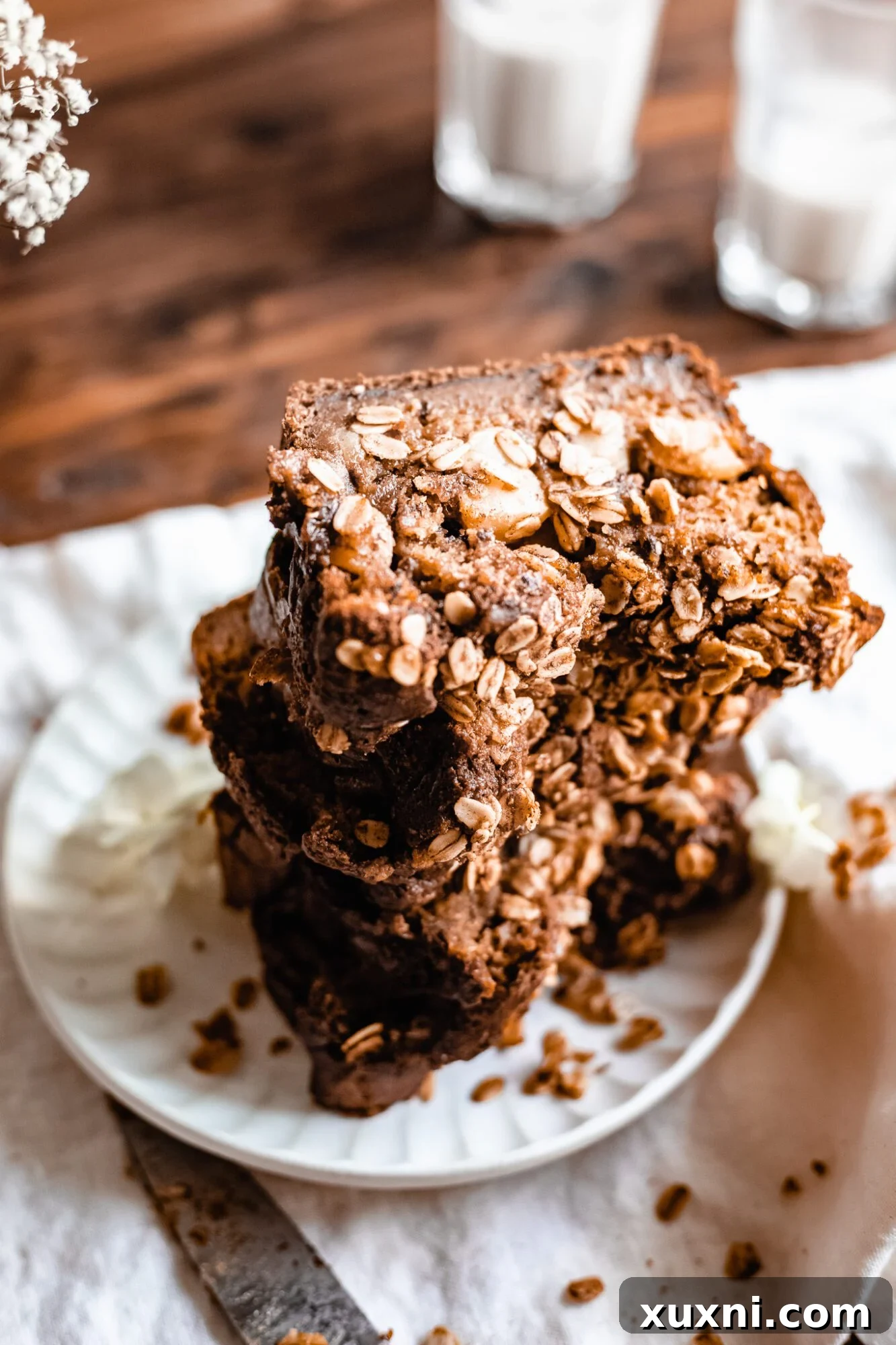 A perfectly baked loaf of vegan apple cinnamon bread, with a rustic oat crumble topping and hints of apple peeking through.