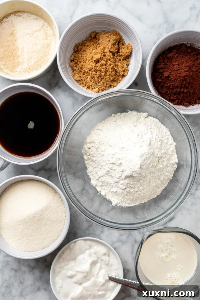 Unbelievably Moist Vegan Chocolate Cake Recipe Lasts Four Days 5 A vibrant display of key vegan chocolate cake ingredients, including yogurt, milk, and cocoa, laid out on a kitchen counter.