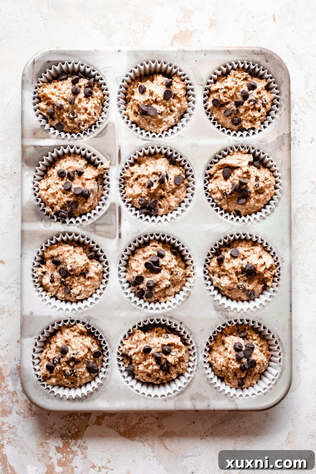 Unbaked banana muffin batter in liners