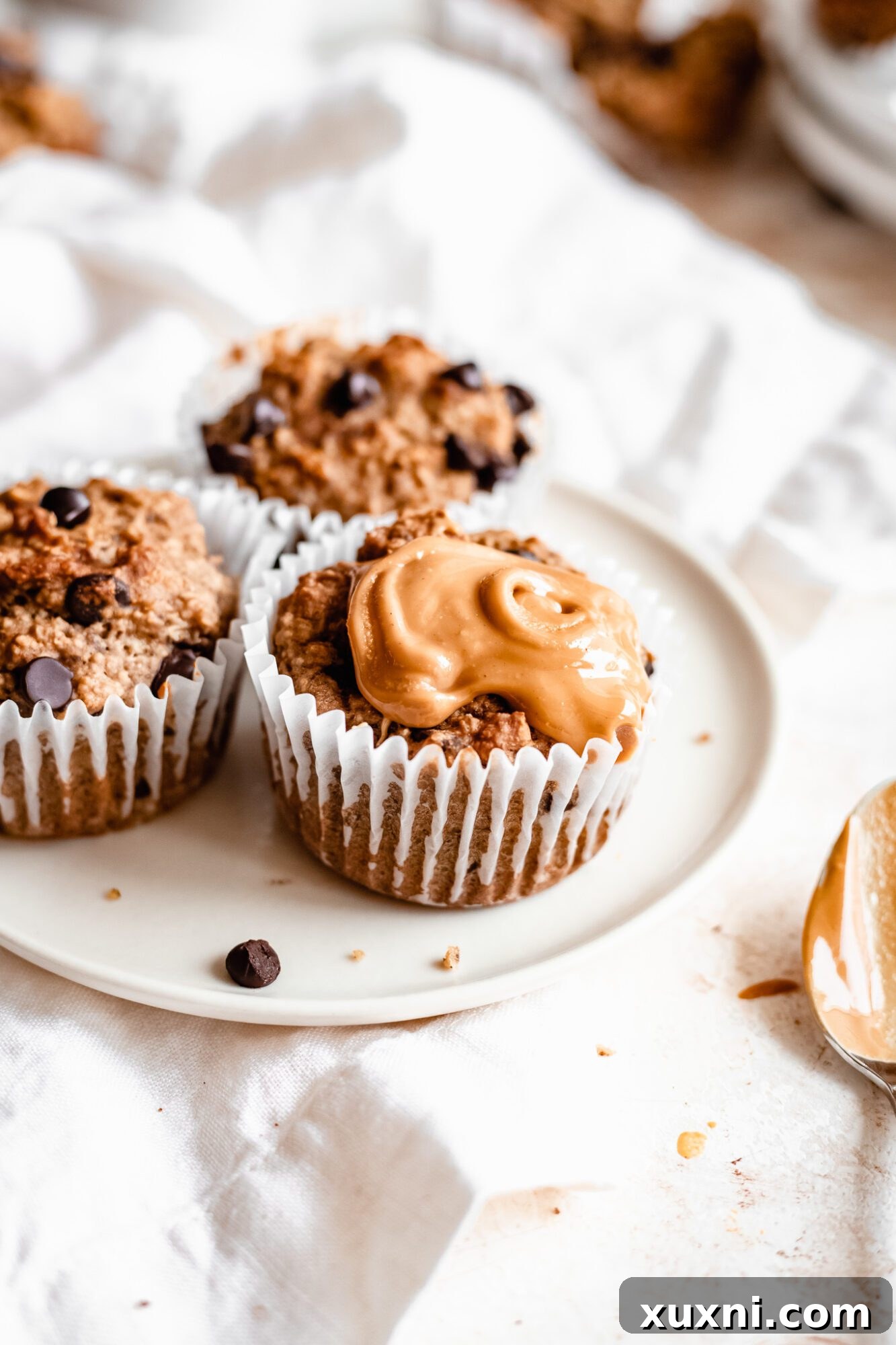 Close-up of a single banana muffin topped with a generous swirl of peanut butter