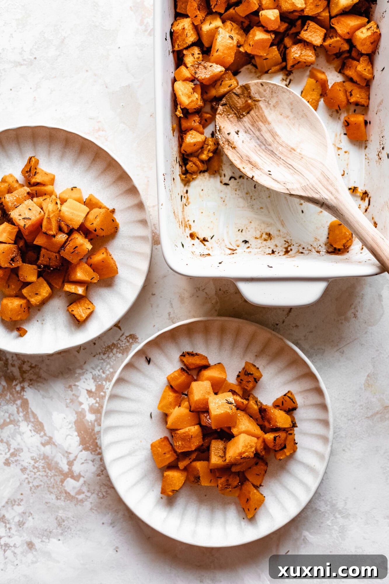 Effortless Golden Roasted Butternut Squash 9 A plate of roasted butternut squash beside a casserole dish, emphasizing its readiness for serving