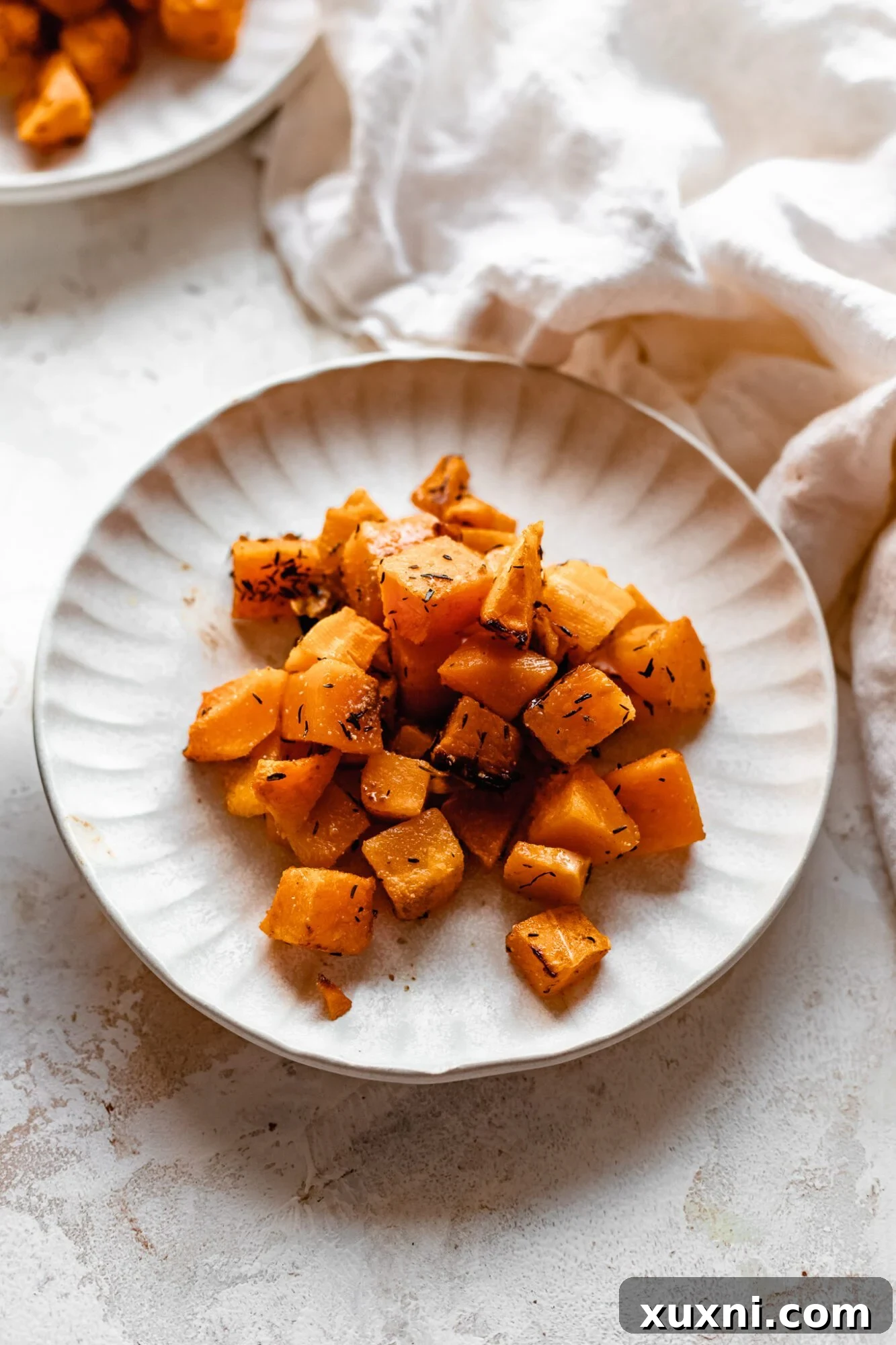 Effortless Golden Roasted Butternut Squash 10 A beautifully presented plate of cooked butternut squash with a dish towel, highlighting its wholesome appeal