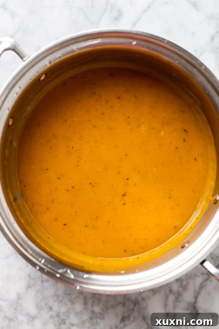 Speedy Silky Vegan Butternut Soup Coconut-Free in 30 Minutes 7 Close-up of a pot of perfectly blended, smooth, and creamy butternut squash soup after using an immersion blender.