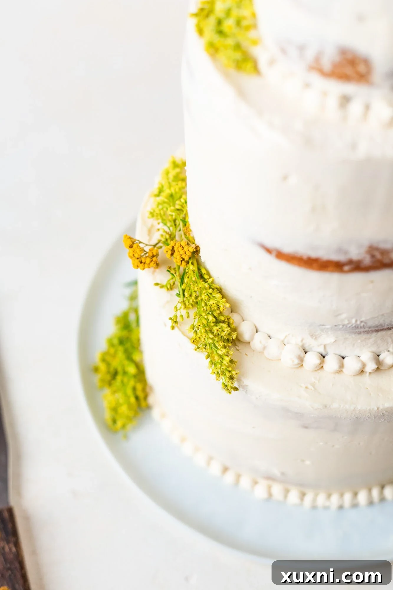 Elegant vegan wedding cake adorned with safe, vibrant fresh flowers