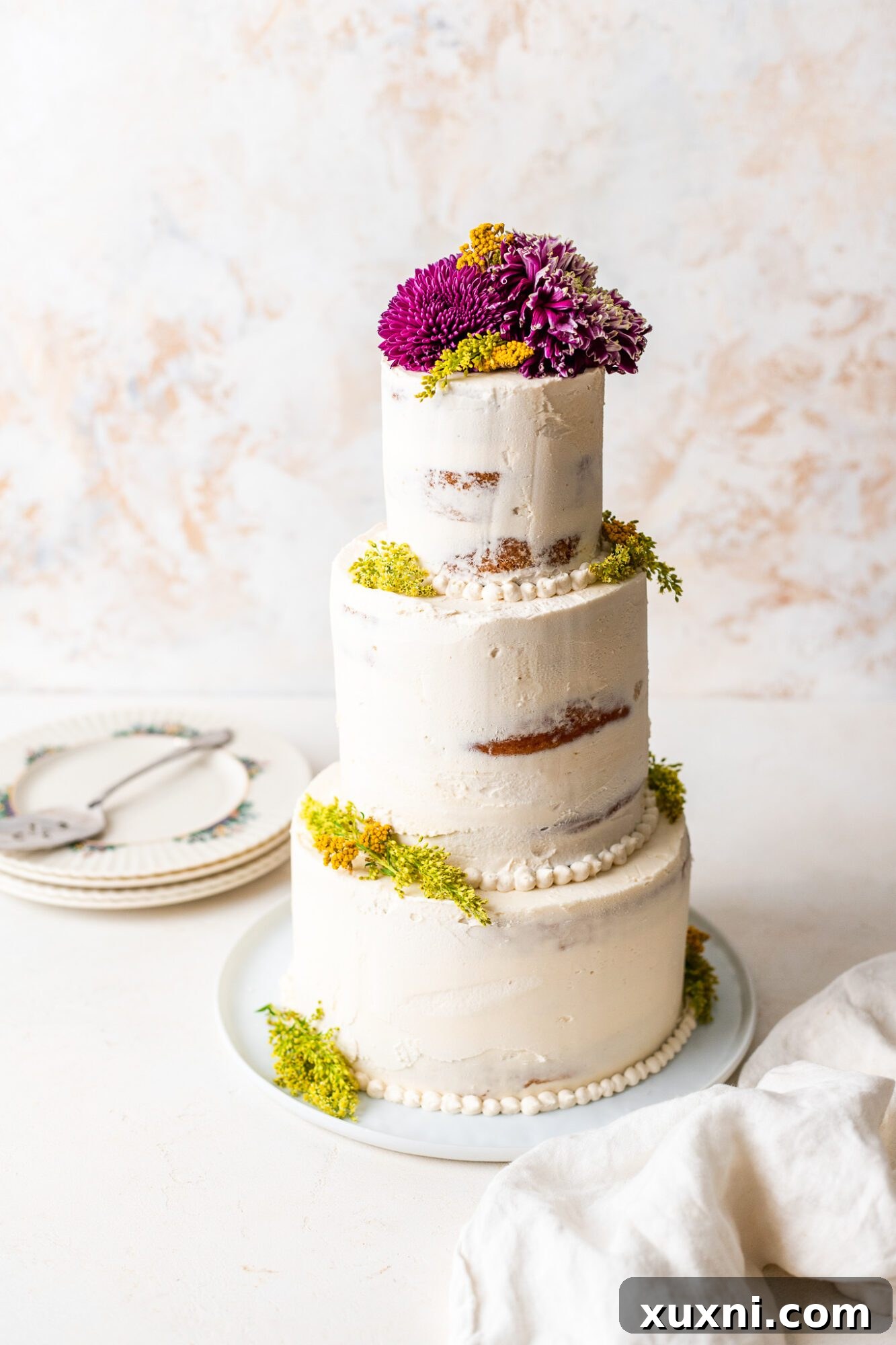 A beautiful three-tier vegan wedding cake adorned with delicate frosting and minimalist decoration