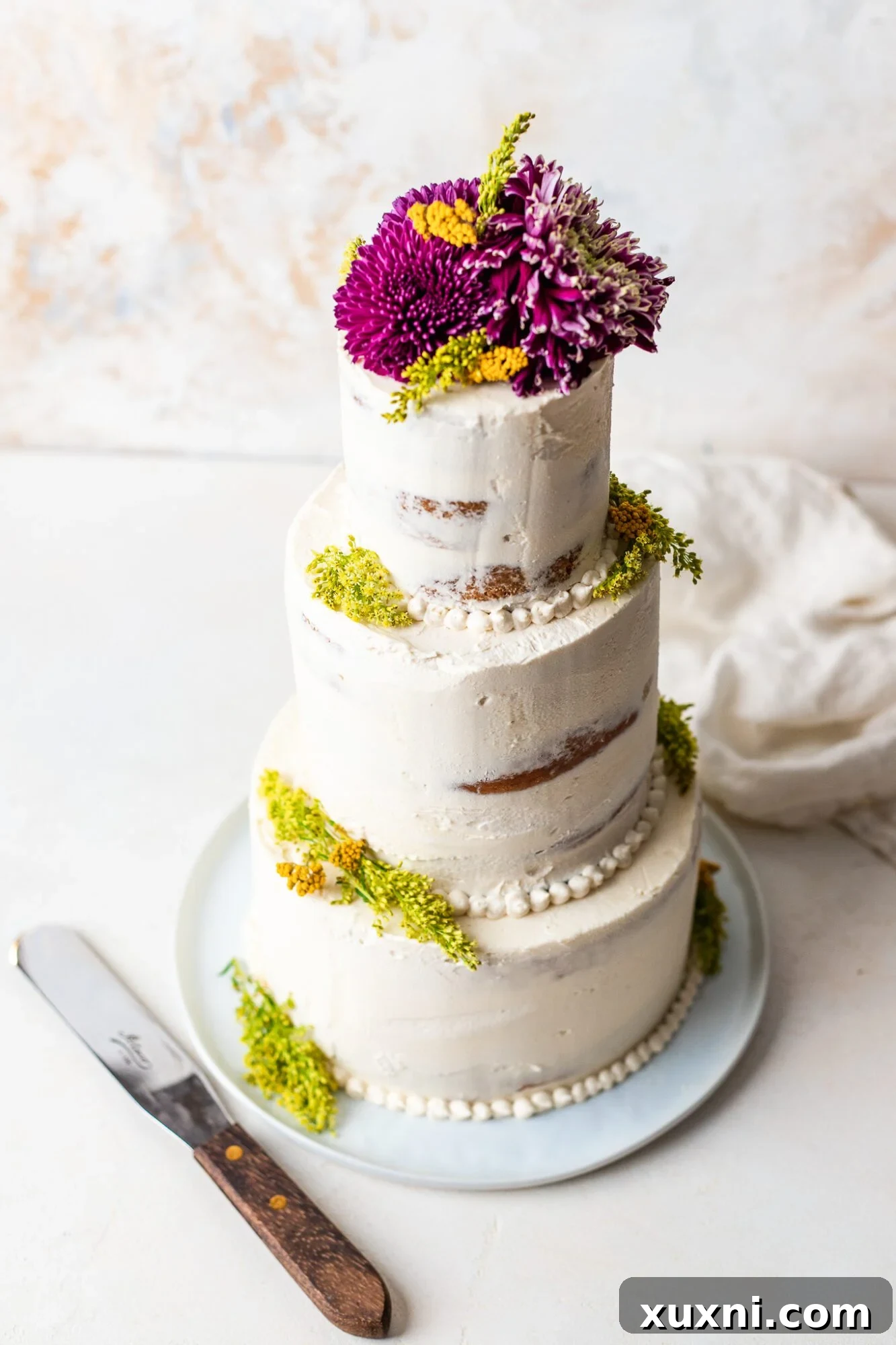 A stunning four-tier vegan wedding cake adorned with delicate frosting and elegant floral details