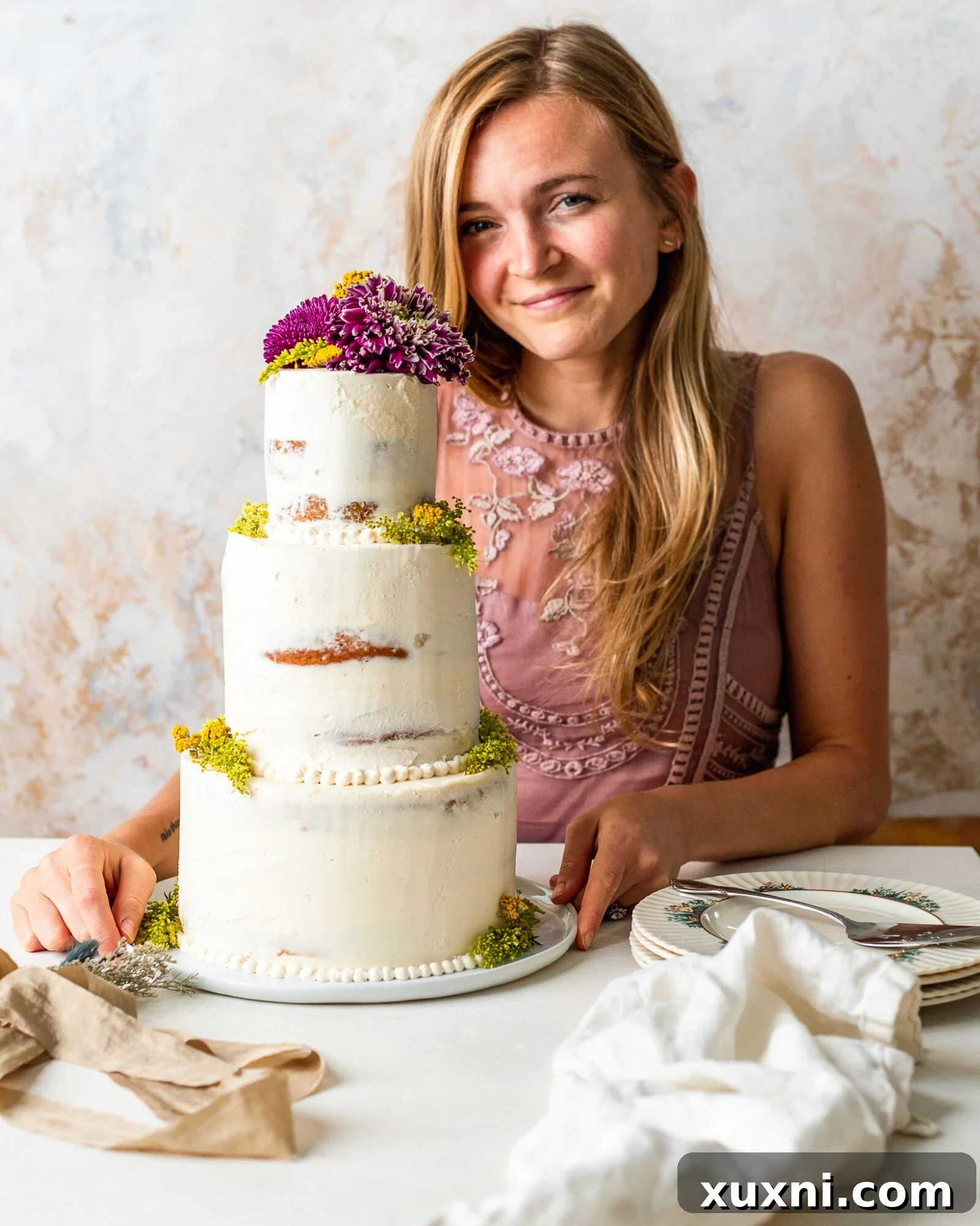 A smiling baker proudly presenting a beautifully crafted homemade vegan wedding cake