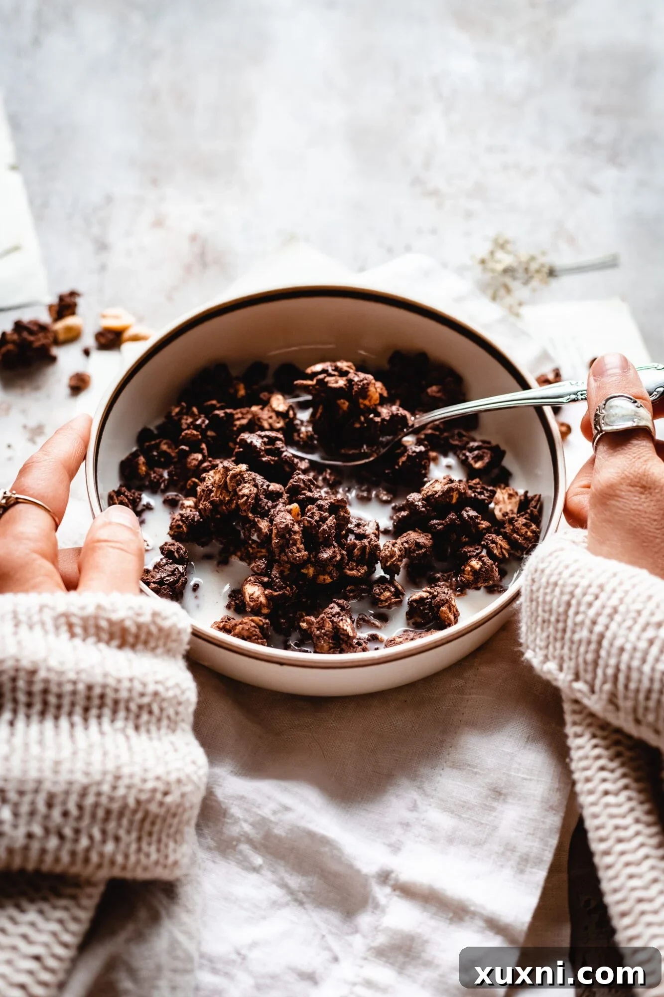 hands holding granola bowl