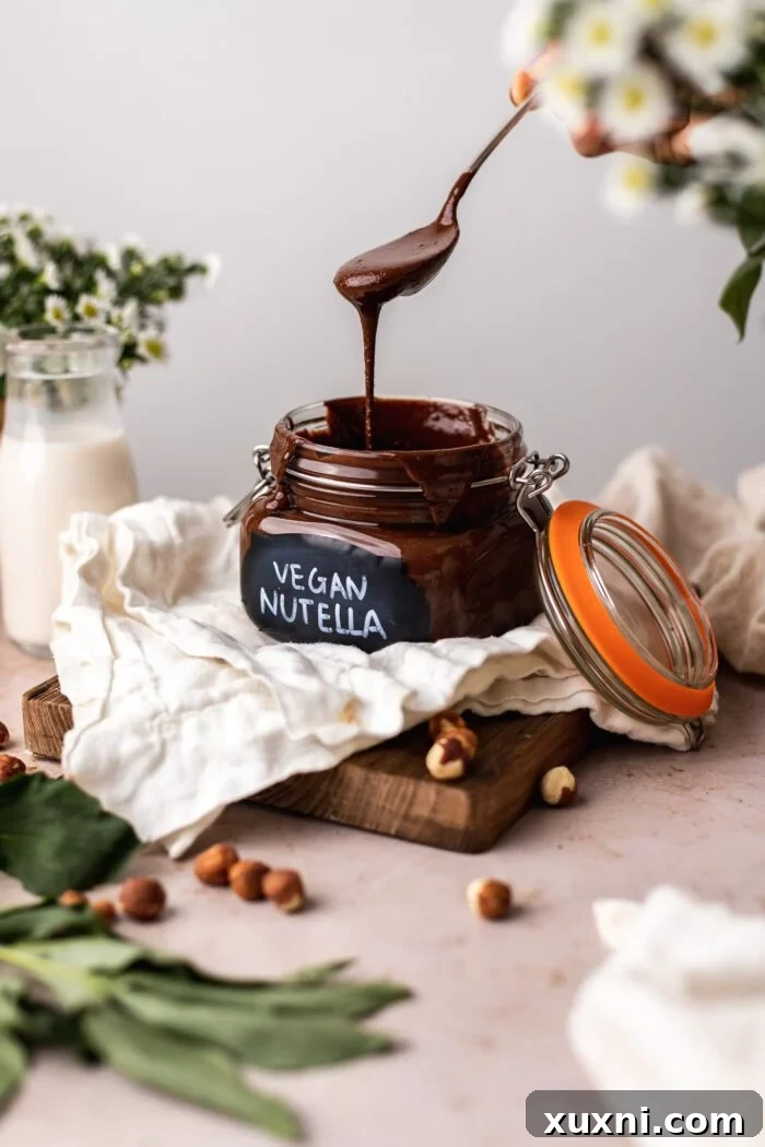 A jar of homemade vegan Nutella with a spoon, highlighting its creamy texture.