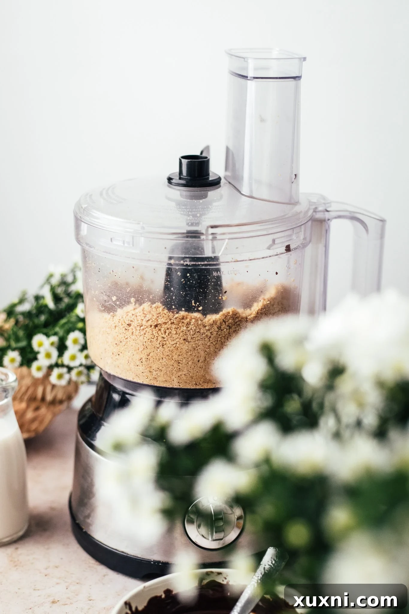 Hazelnuts being blended in a food processor, starting to form a butter.