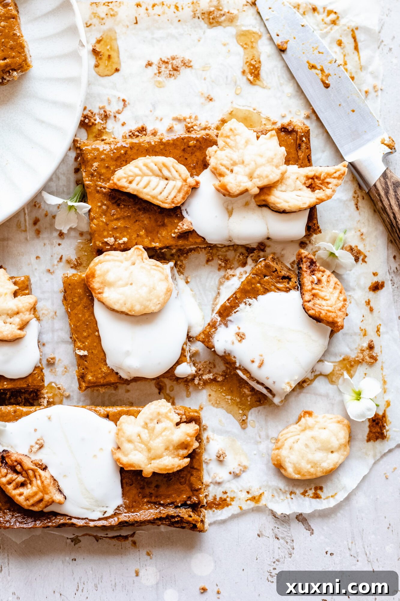 A single pumpkin bar generously topped with light and airy coconut cream, presented on a plate for a decadent finish.
