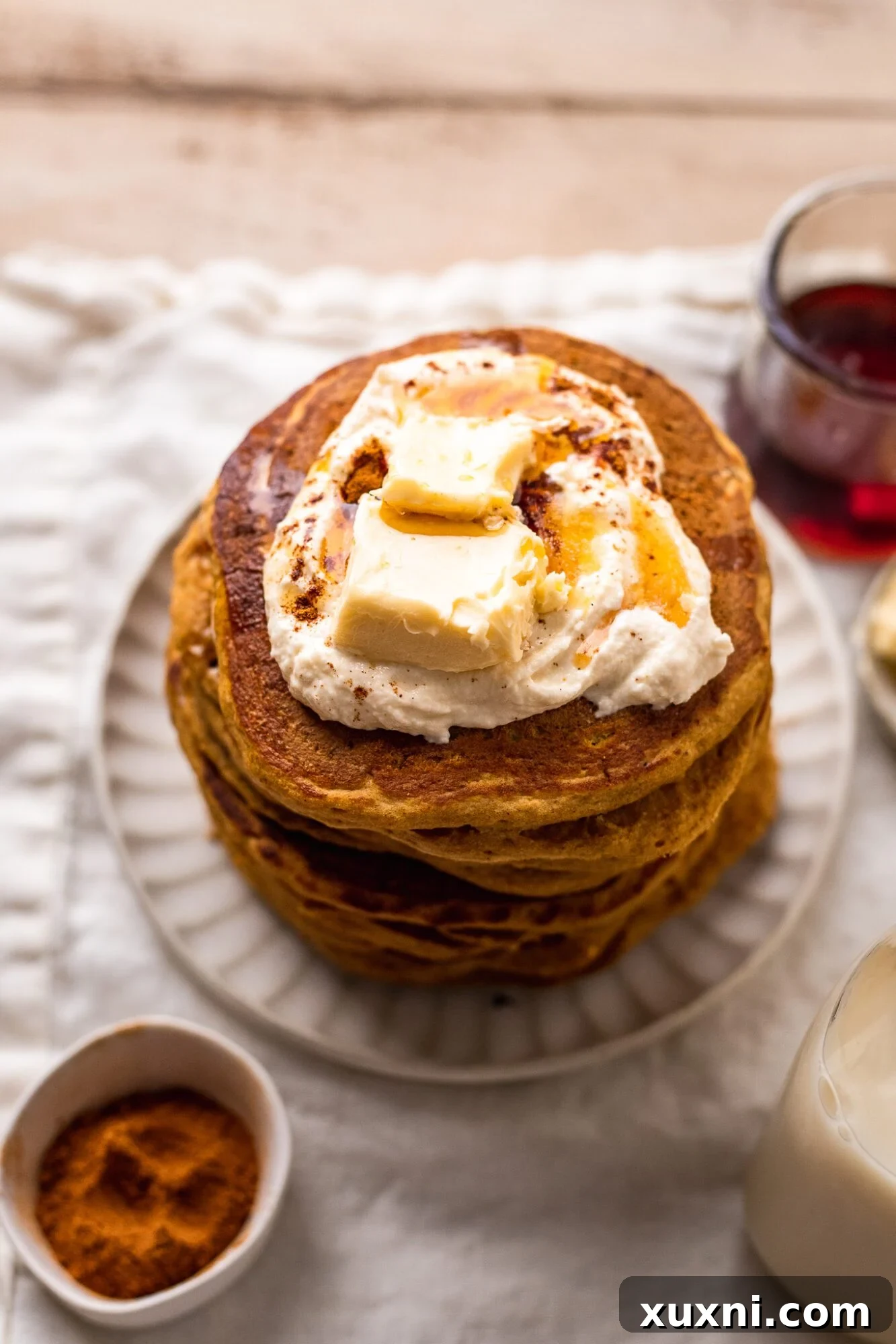 stack of fluffy vegan pumpkin pancakes with vegan butter