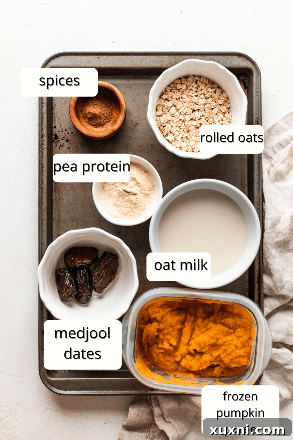 Ingredients for a creamy vegan pumpkin pie smoothie: pumpkin puree, dates, oats, oat milk, maple syrup, pumpkin pie spice, pea protein, vanilla extract.
