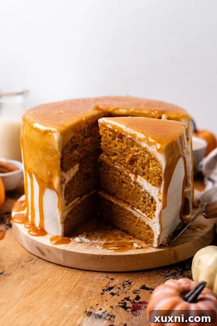 Sliced vegan pumpkin cake revealing its moist interior and generous frosting layer.