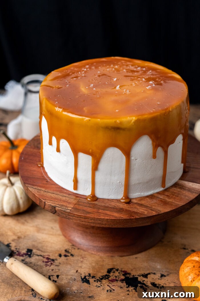 Assembled and frosted vegan pumpkin cake ready for final decorations, showcasing its smooth finish.