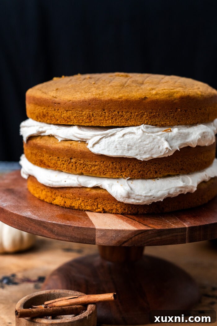 Applying creamy vegan cream cheese frosting to a cake layer, ready for stacking.
