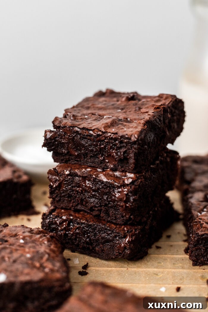 Stacked vegan brownies with gooey centers and crinkle tops, a truly irresistible dessert.