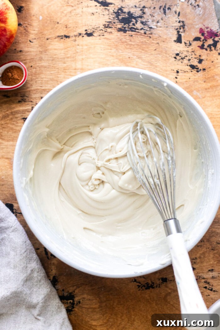 Smooth, creamy maple cream cheese frosting in a bowl, ready to be spread.