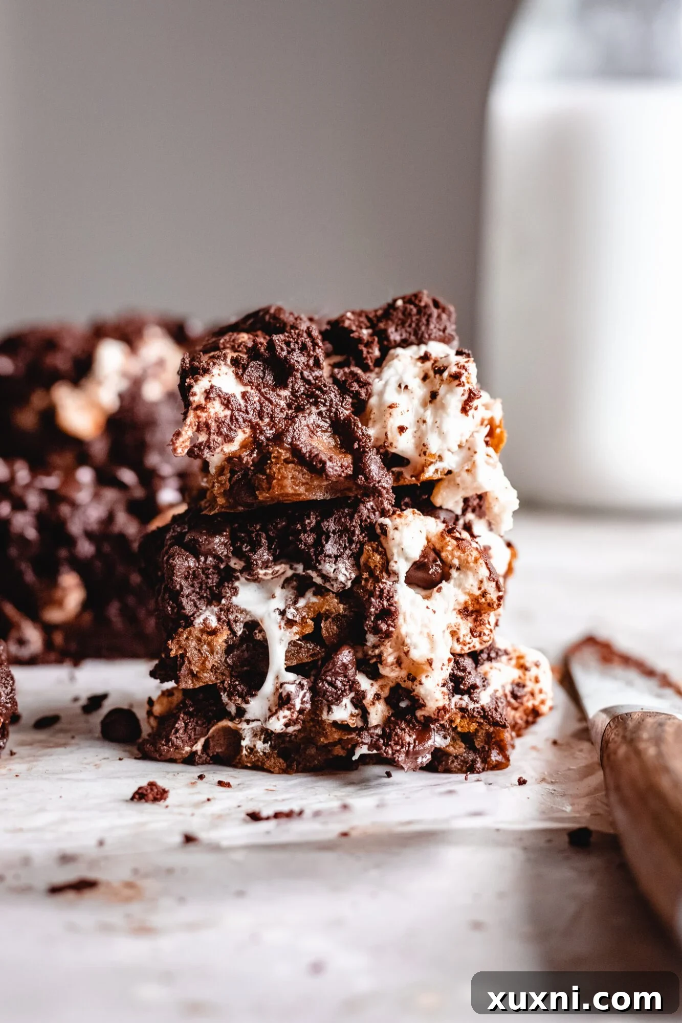 Vegan Smores Brownie Cookie Recipe 13 stacked slices of vegan s'mores brookies on a white plate, showcasing the gooey marshmallow