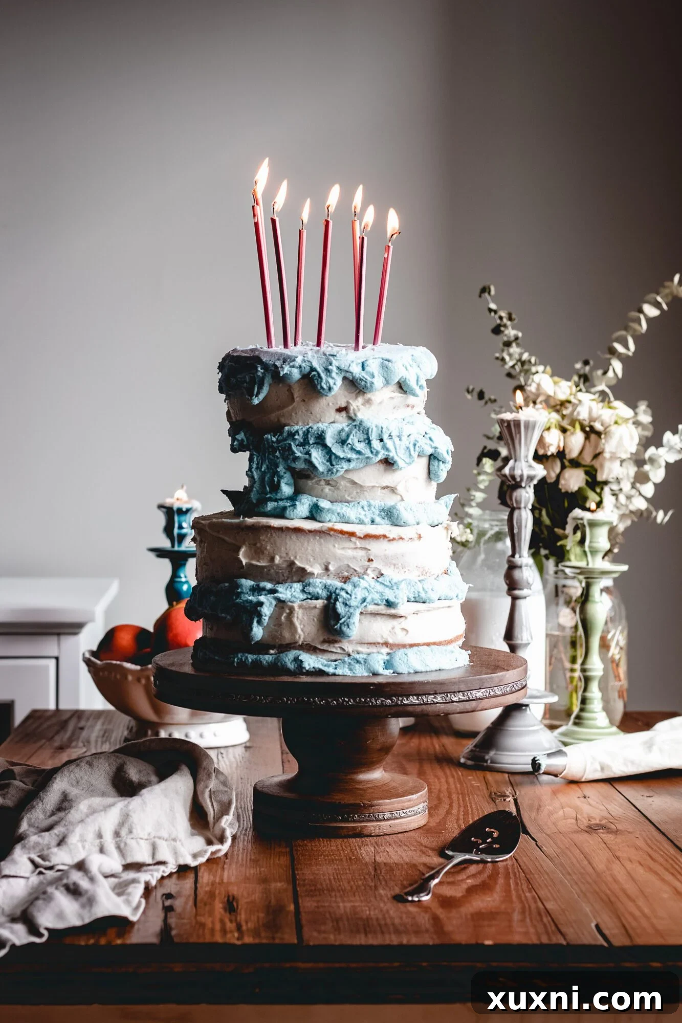 Close-up of the whimsical, slightly tilted tiers of the Sleeping Beauty birthday cake, showcasing the smooth vegan buttercream and hints of vanilla cake layers.