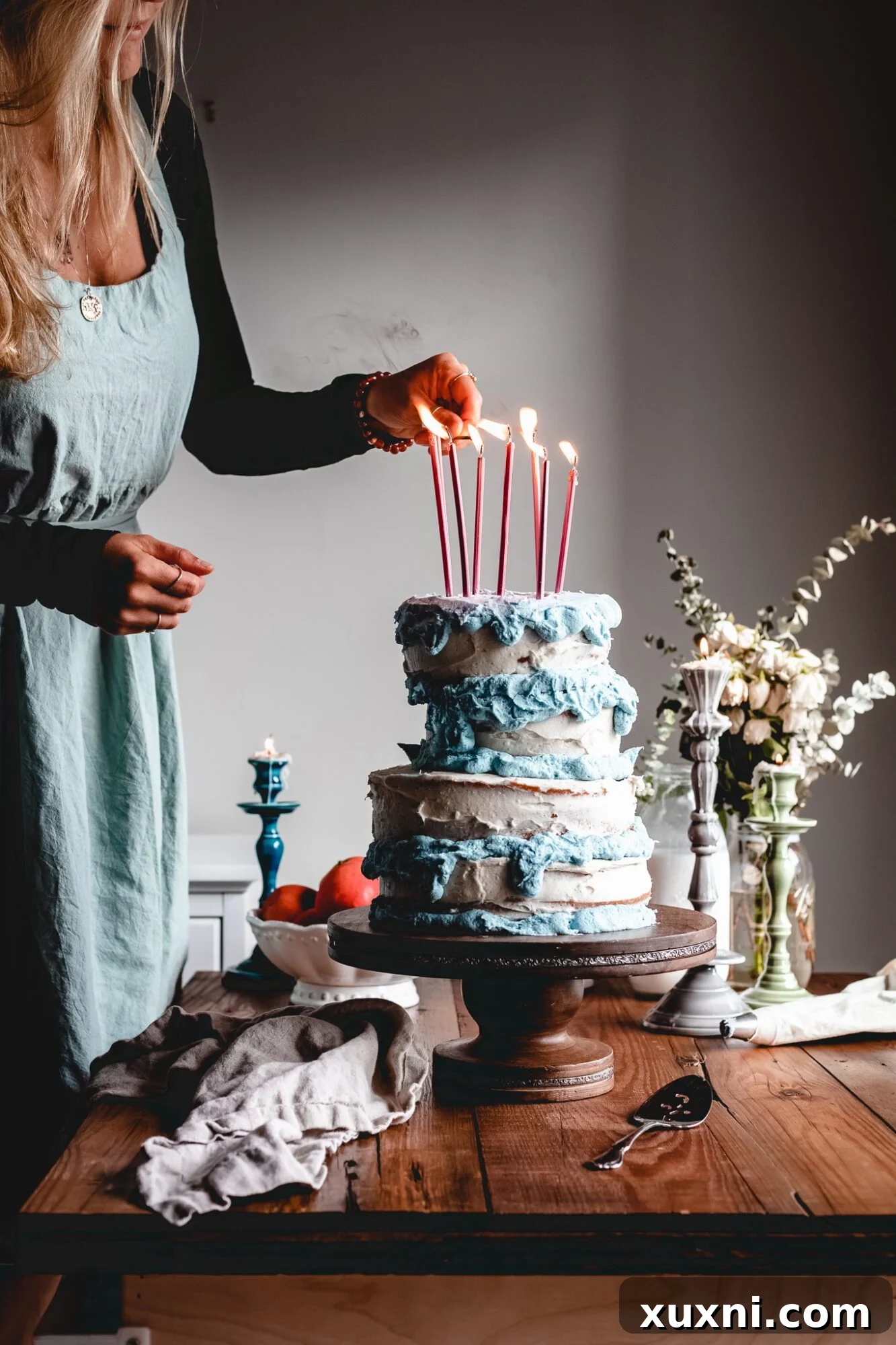 A person lighting the pink candles on the vegan Sleeping Beauty birthday cake, ready for a magical celebration.