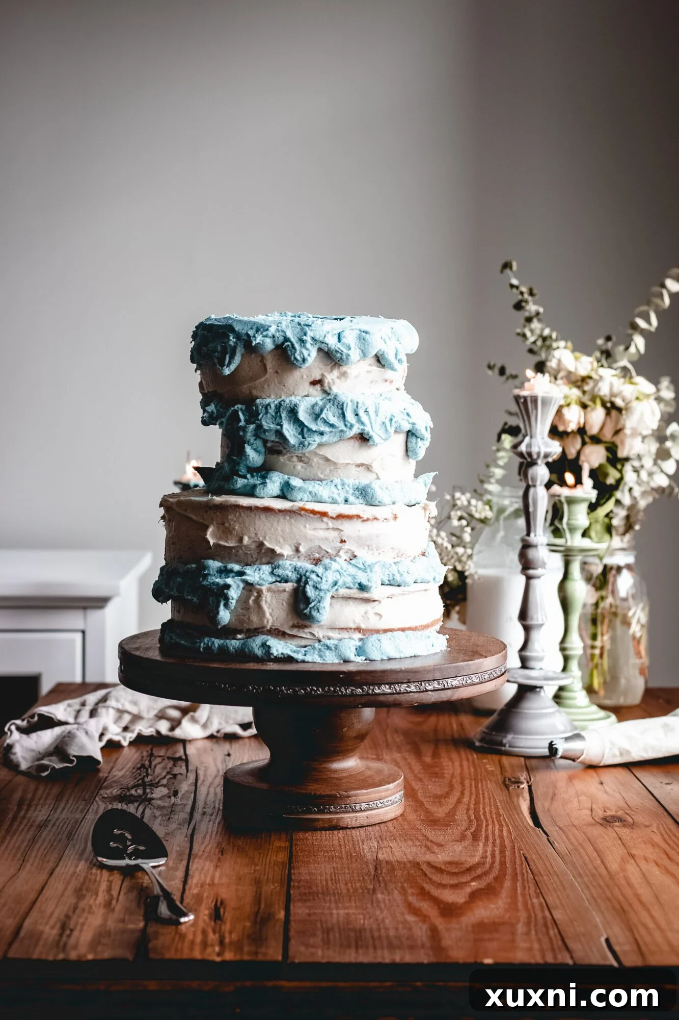 The beautifully iced vegan Sleeping Beauty cake, featuring charming blue frosting drips along the edges of each tier, creating a whimsical effect.