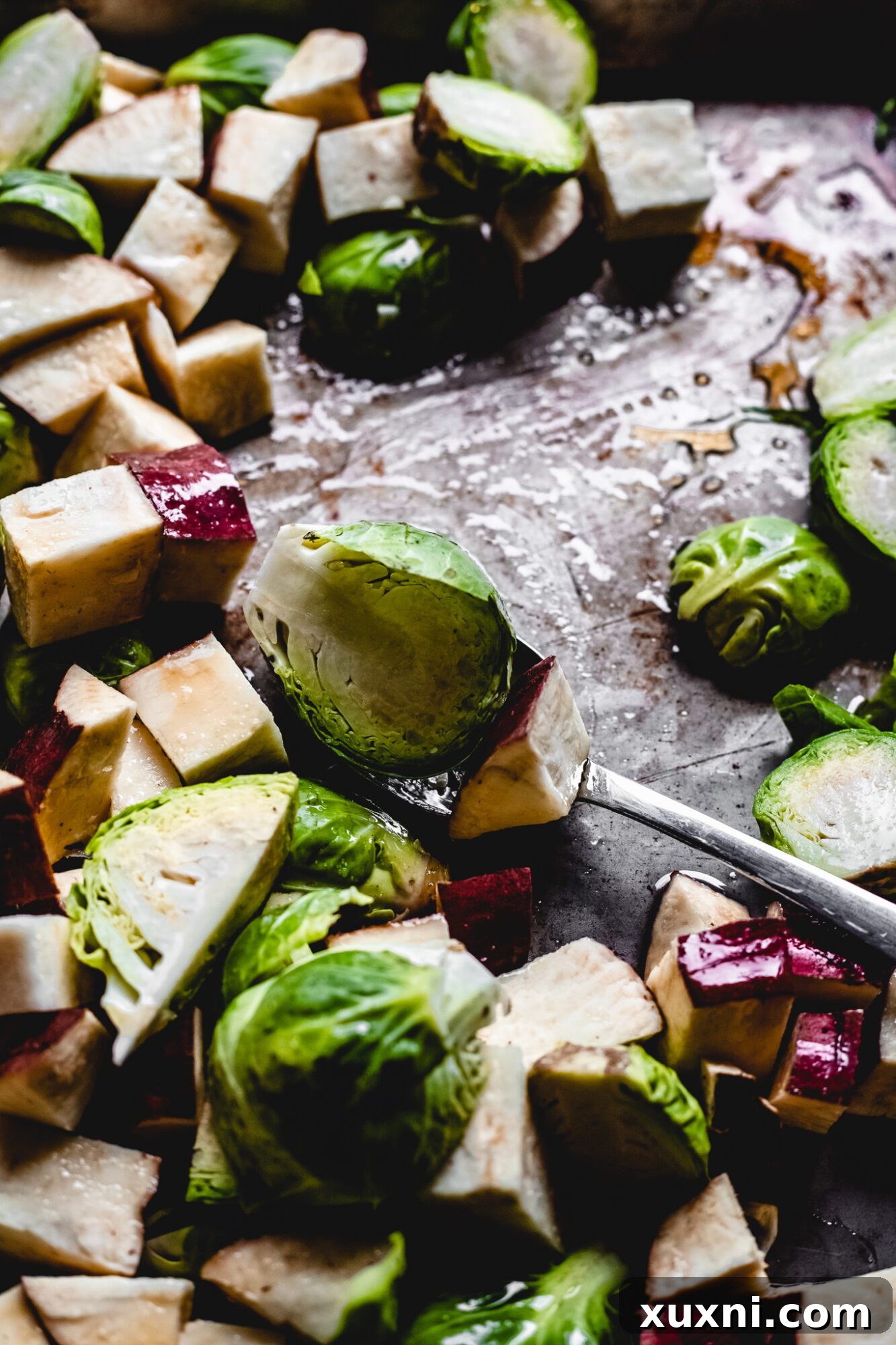 A hand reaching for a perfectly roasted Brussels sprout from a serving bowl, highlighting the dish's appealing texture.